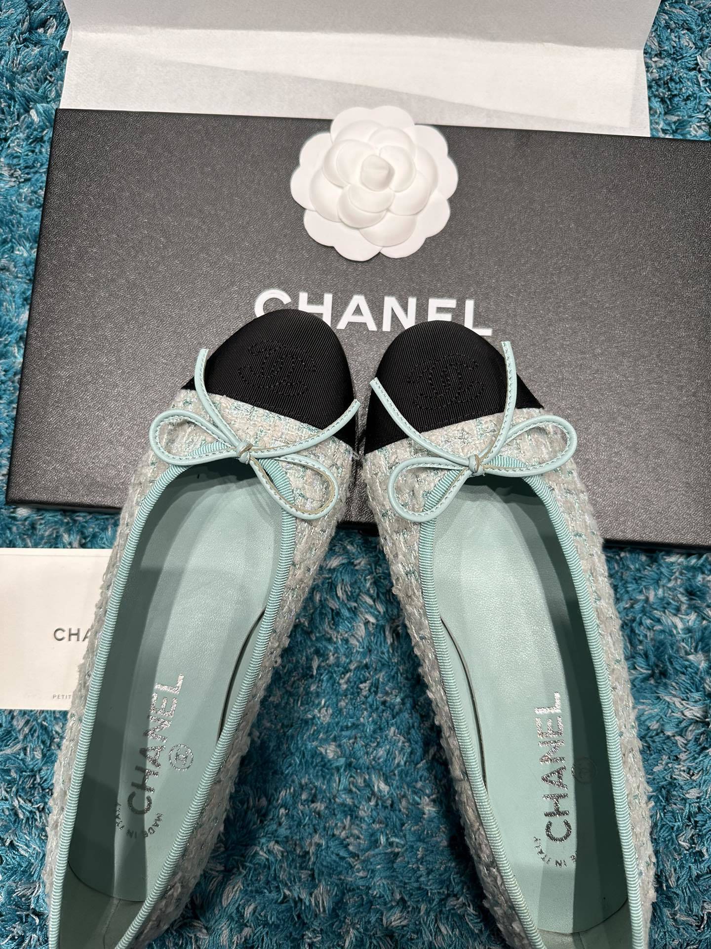 Luxury Chanel ballet flats featuring light blue tweed fabric, black grosgrain cap-toes with CC logo, and a delicate bow detail. - Hình 3