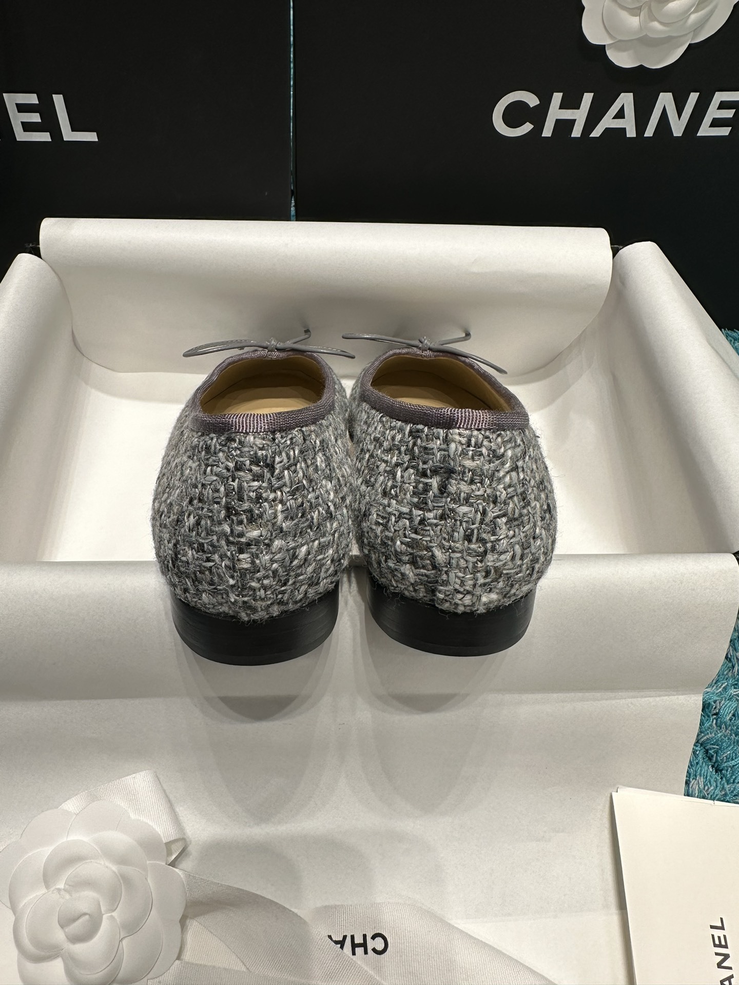 Top view of Chanel grey tweed ballet flats with grey leather toe caps featuring the CC logo and decorative bows in a Chanel box. - Hình 6