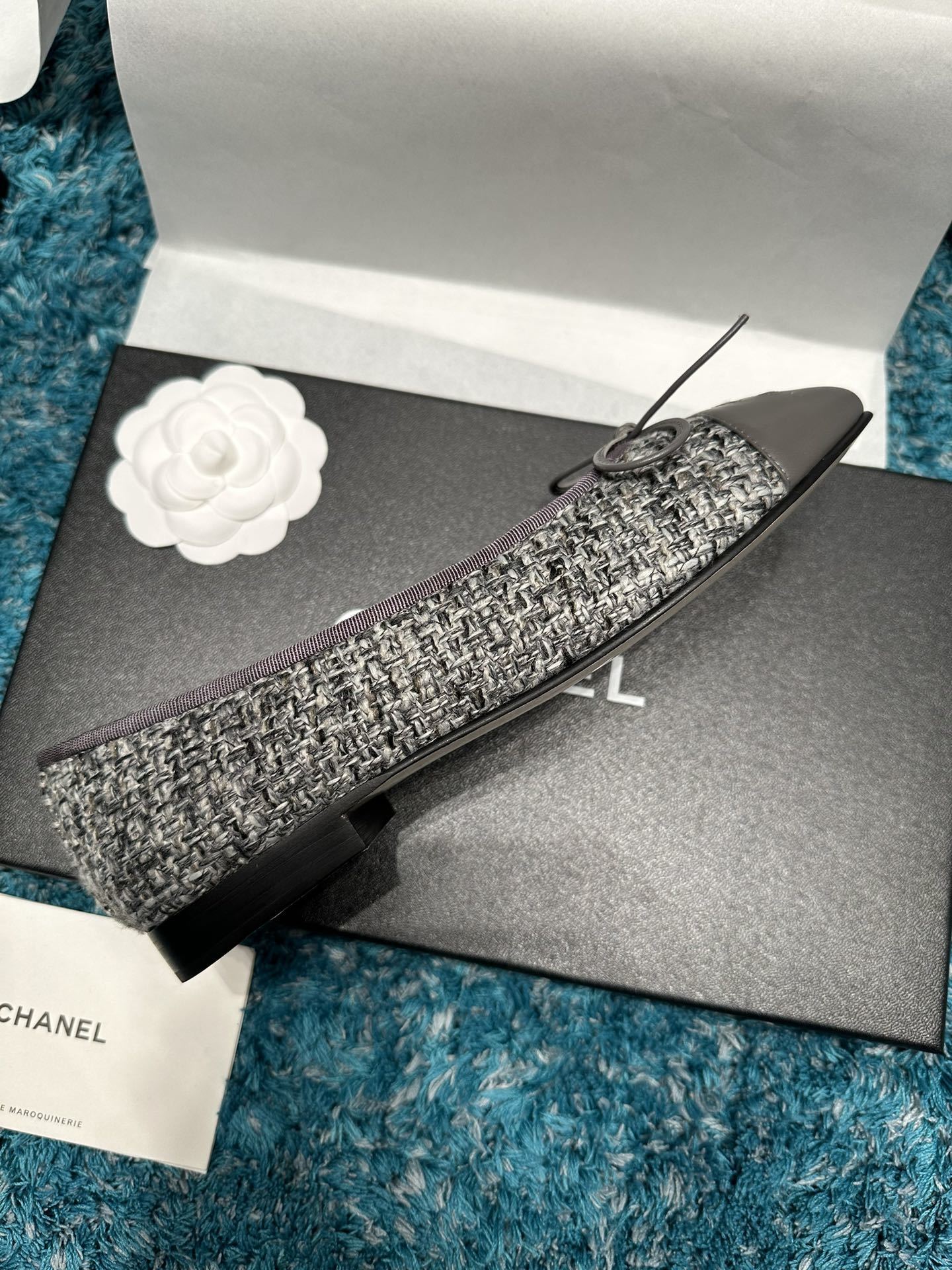 Top view of Chanel grey tweed ballet flats with grey leather toe caps featuring the CC logo and decorative bows in a Chanel box. - Hình 3
