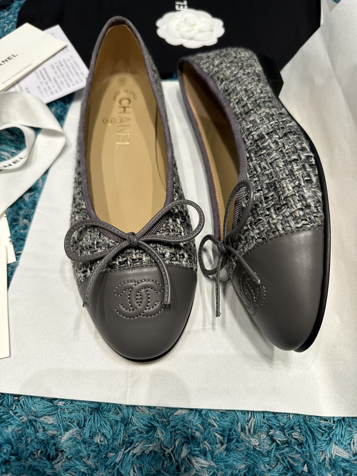 Top view of Chanel grey tweed ballet flats with grey leather toe caps featuring the CC logo and decorative bows in a Chanel box. - Hình 2