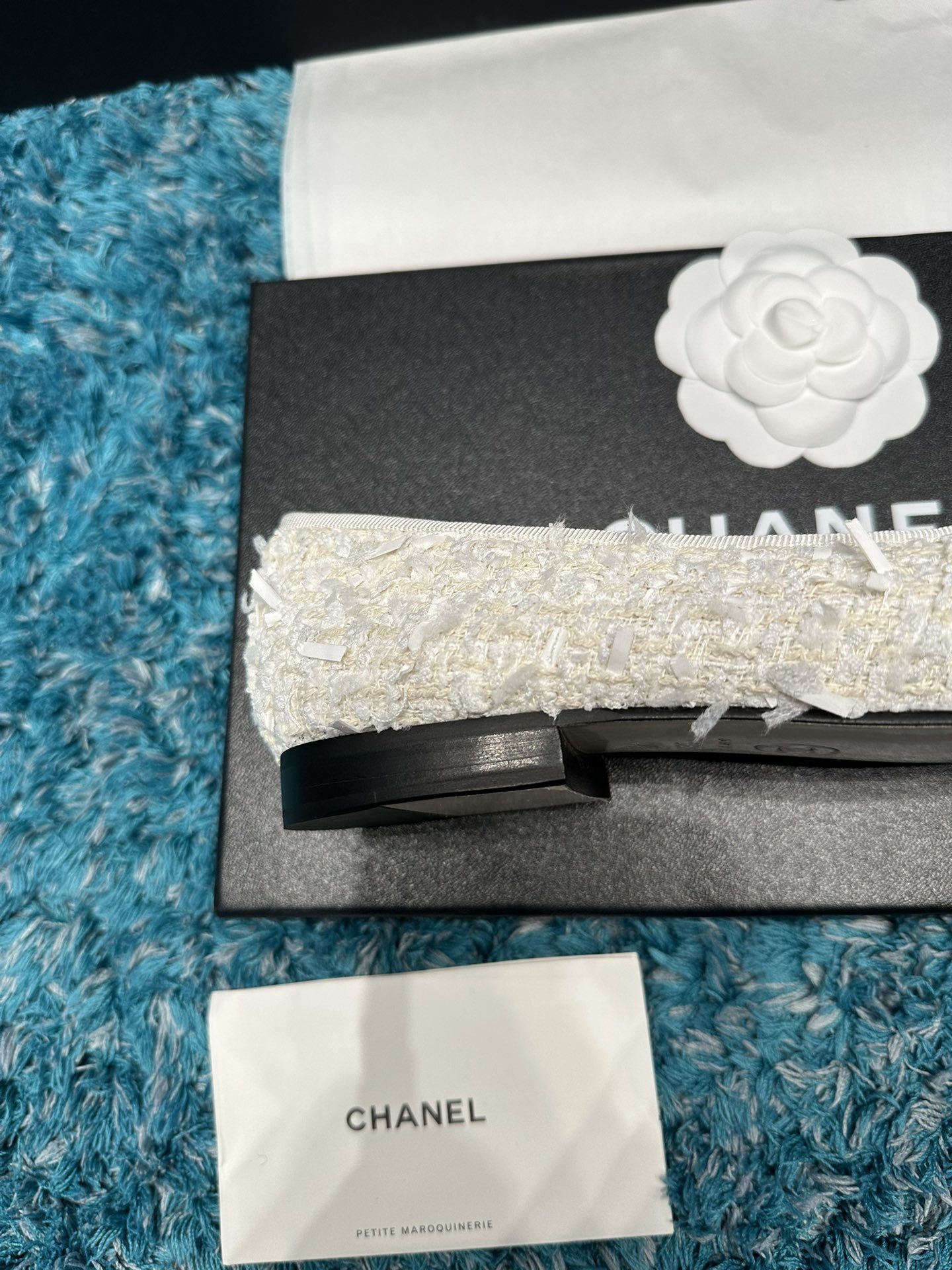 A pair of Chanel white tweed ballet flats with black toe caps and white bows, presented in a Chanel box with branded ribbons. - Hình 8