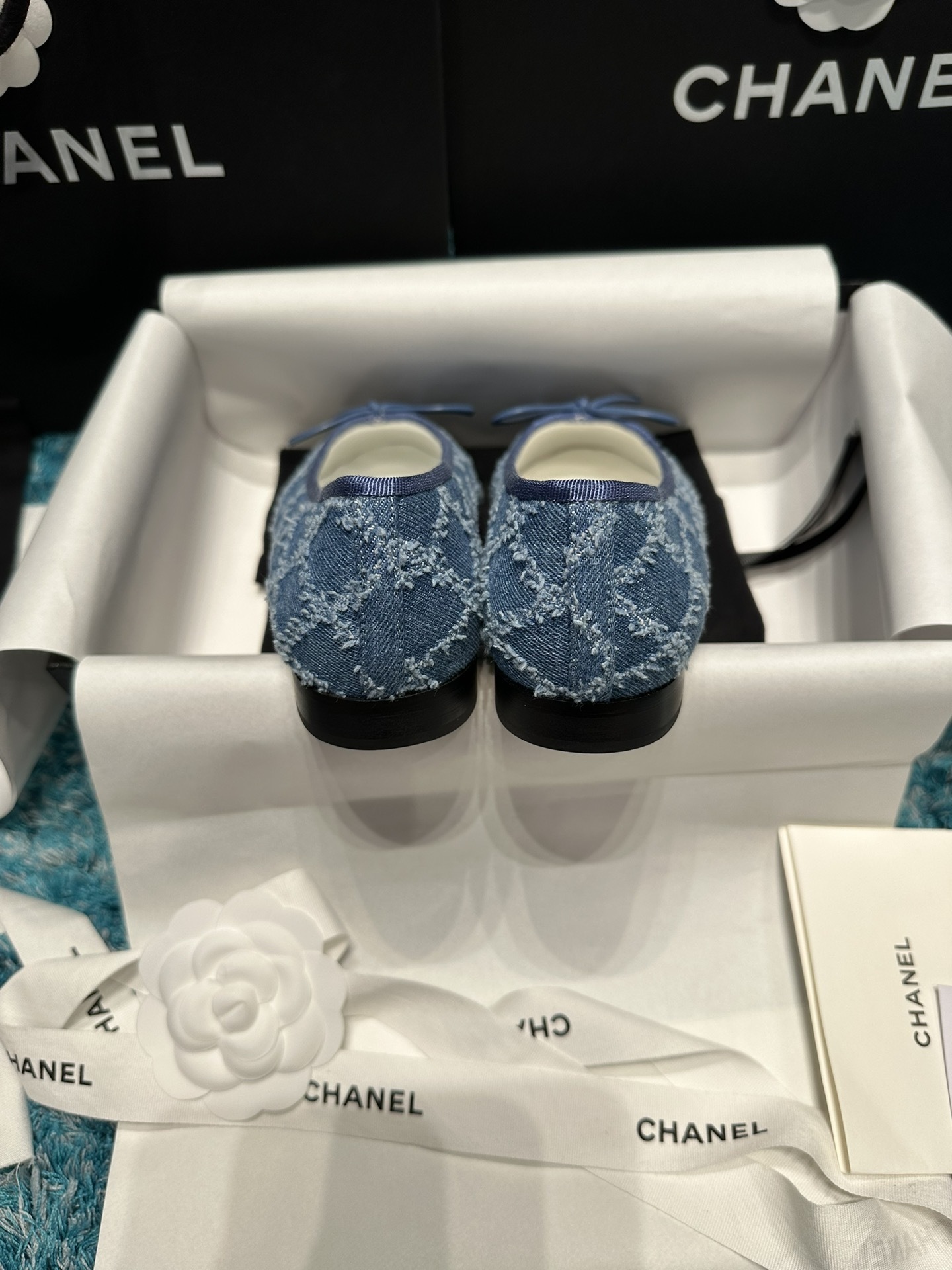 Pair of luxury Chanel blue denim ballet flats with black toe caps and delicate bows inside a brand box. - Hình 8
