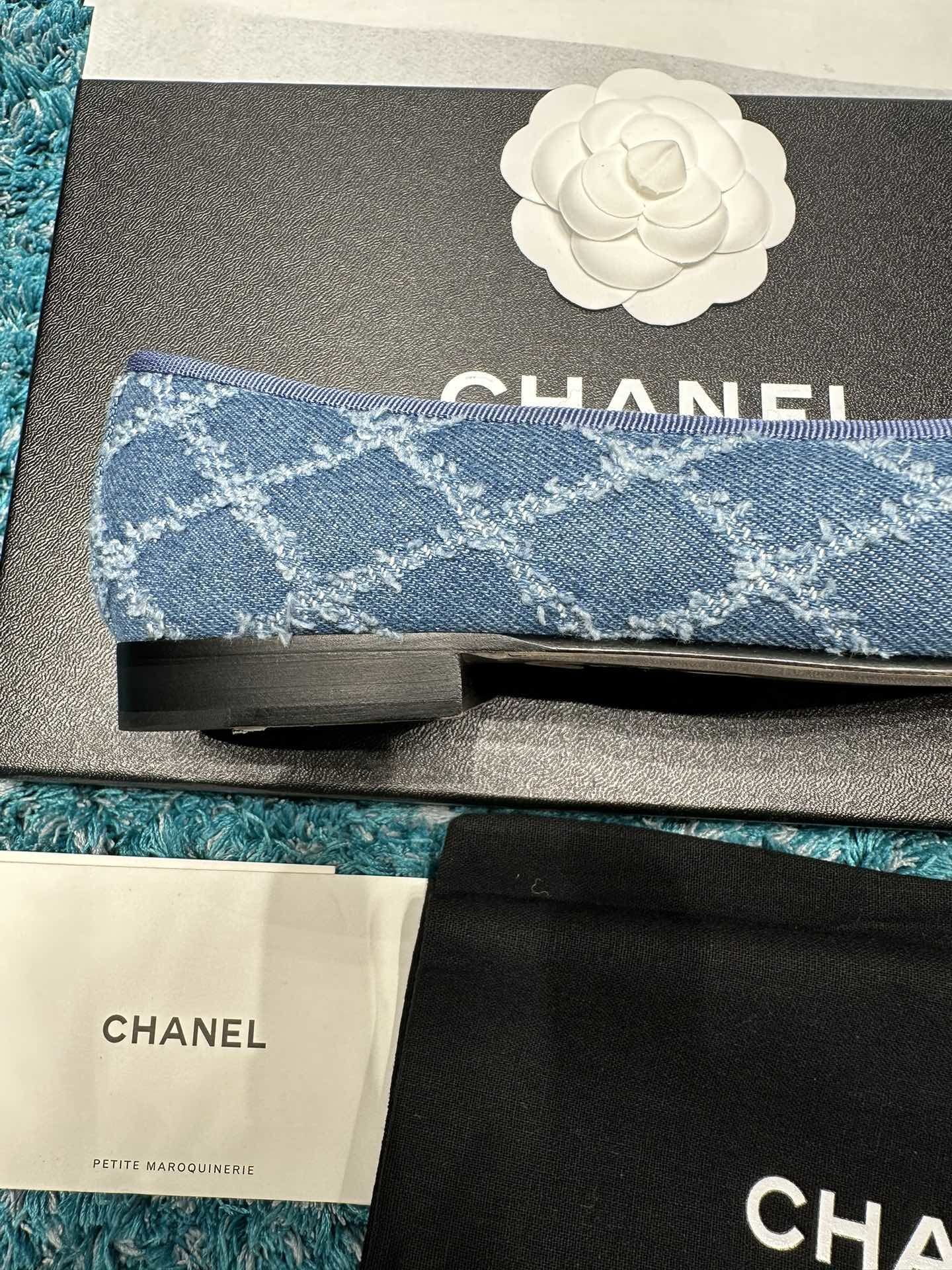 Pair of luxury Chanel blue denim ballet flats with black toe caps and delicate bows inside a brand box. - Hình 7