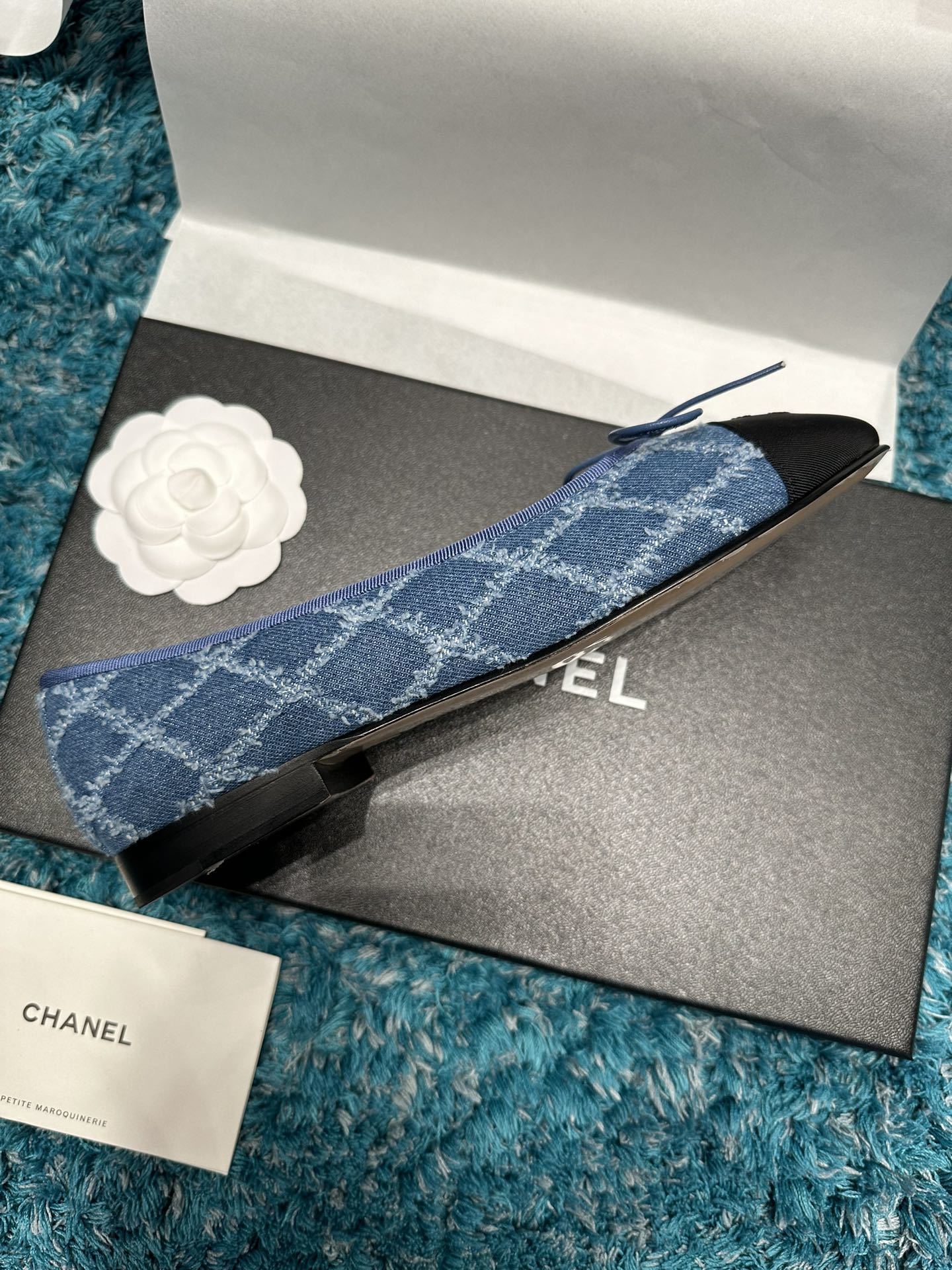 Pair of luxury Chanel blue denim ballet flats with black toe caps and delicate bows inside a brand box. - Hình 4