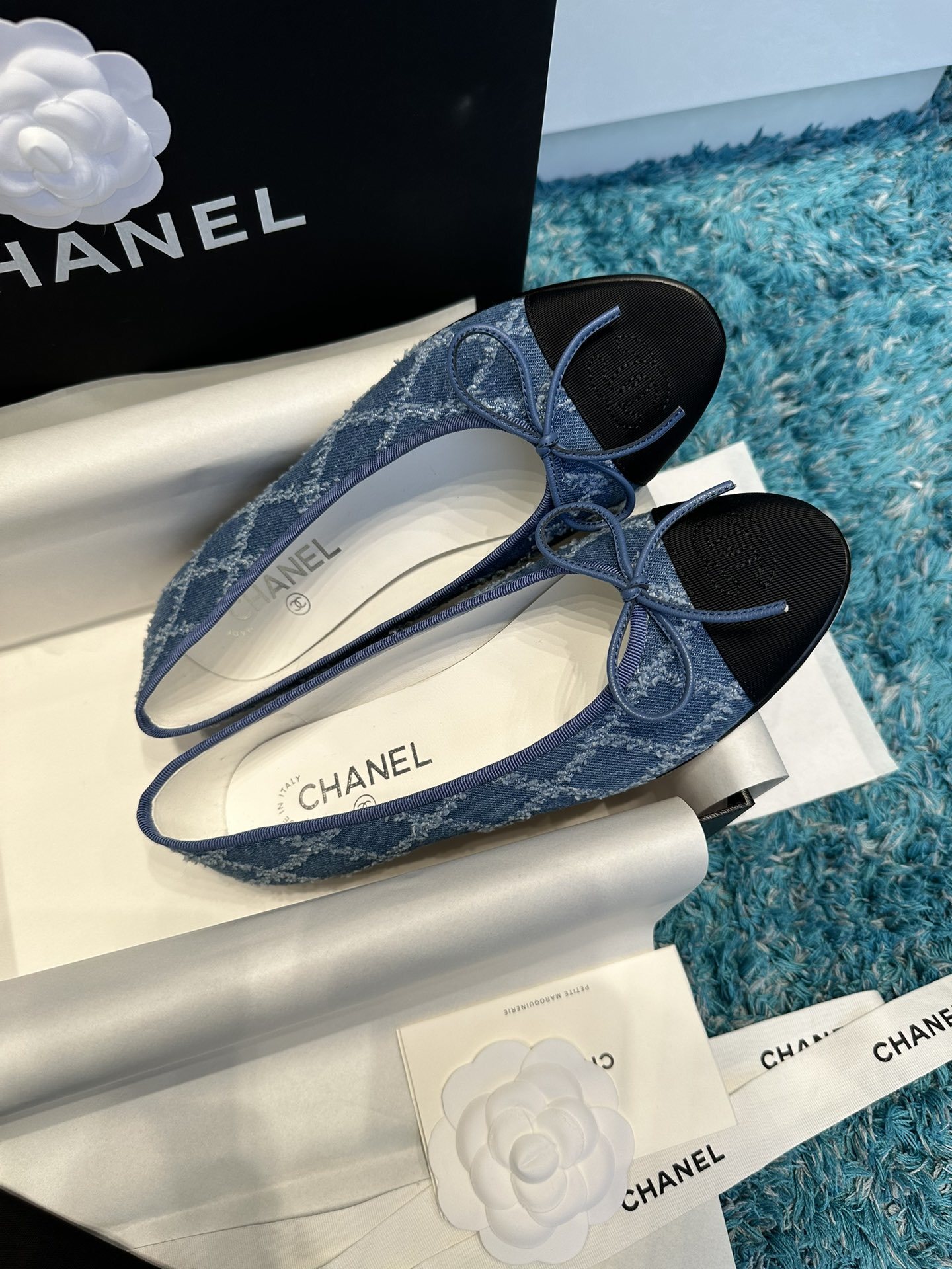 Pair of luxury Chanel blue denim ballet flats with black toe caps and delicate bows inside a brand box. - Hình 2