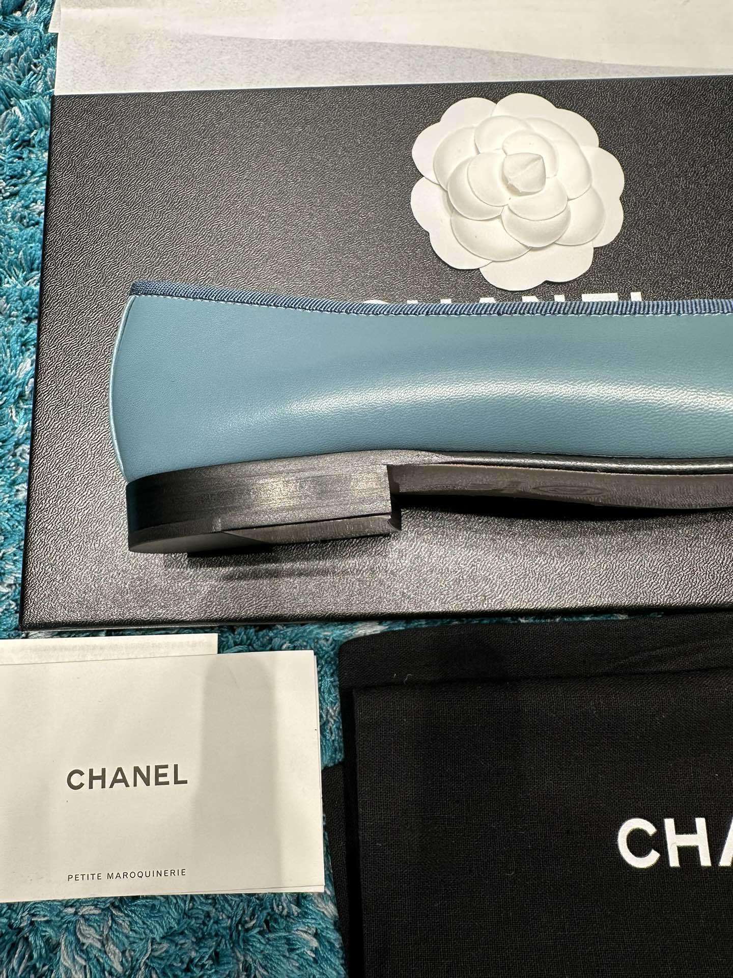 Pair of blue Chanel ballet flats with black toe caps and bow details in original packaging - Hình 8