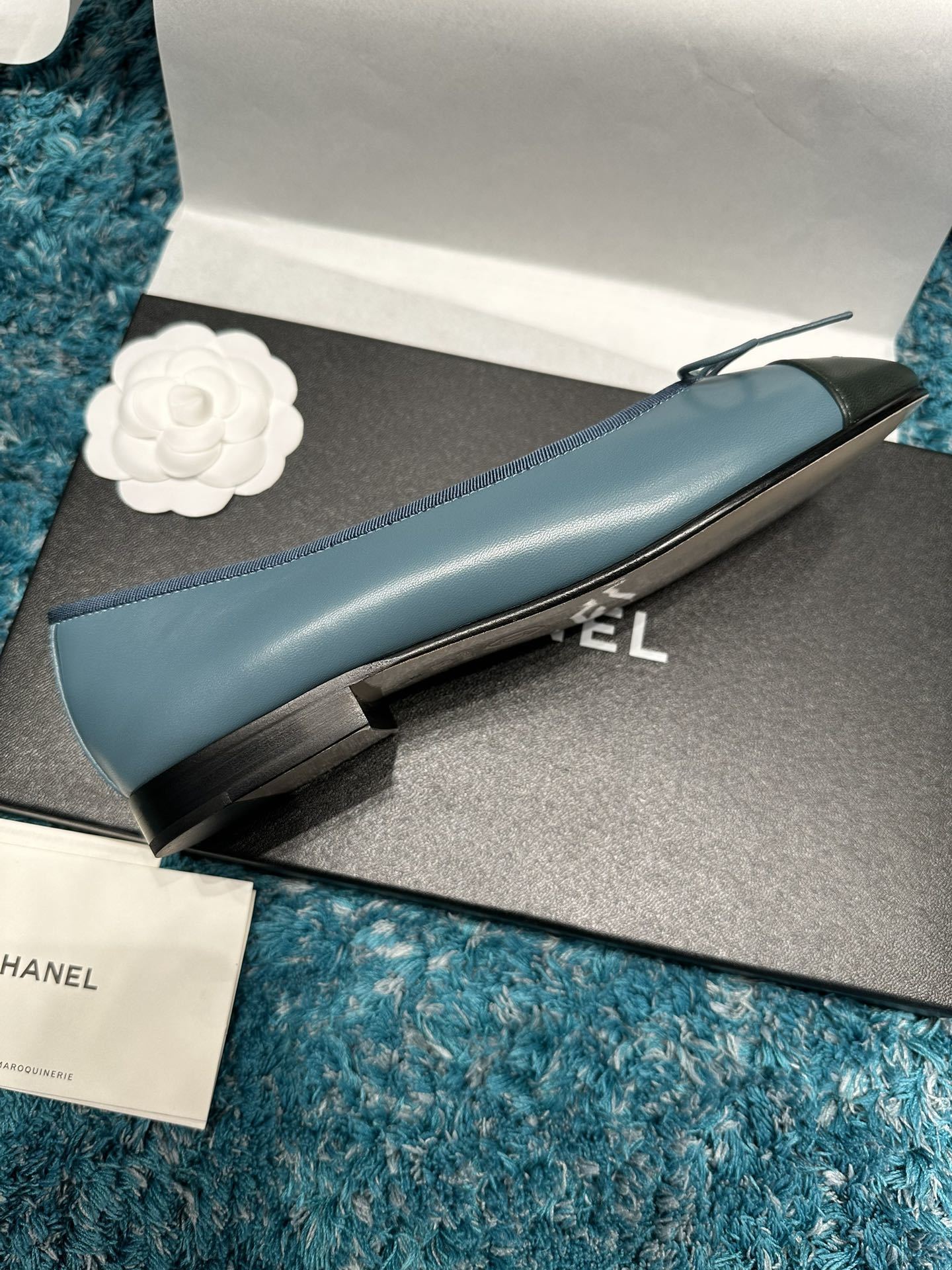 Pair of blue Chanel ballet flats with black toe caps and bow details in original packaging - Hình 7