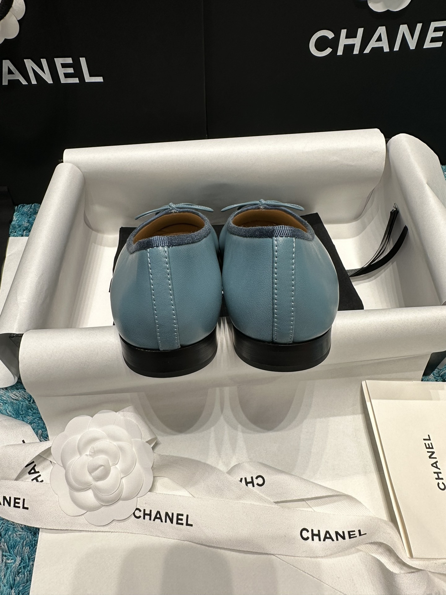 Pair of blue Chanel ballet flats with black toe caps and bow details in original packaging - Hình 3