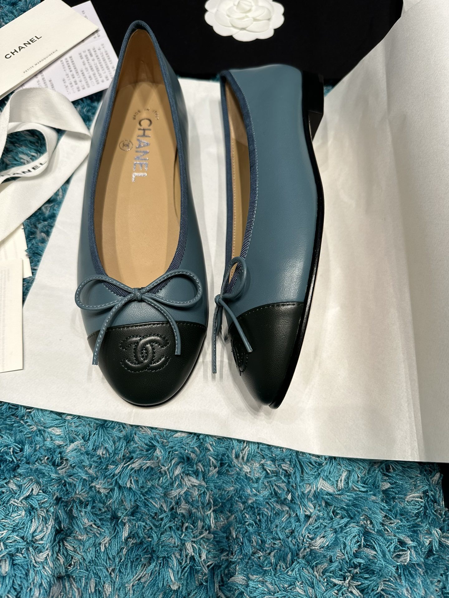 Pair of blue Chanel ballet flats with black toe caps and bow details in original packaging - Hình 2