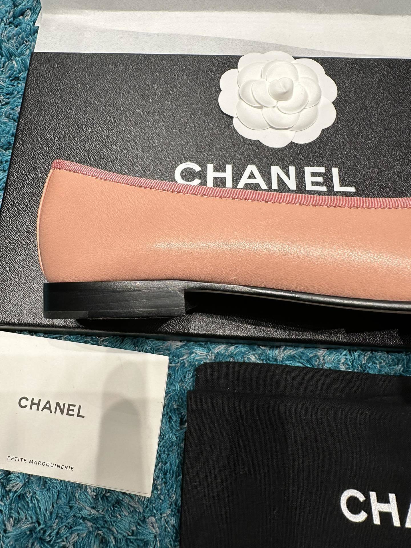 A pair of pink Chanel ballerina flats with black toe caps and bow details sitting in original packaging. - Hình 8