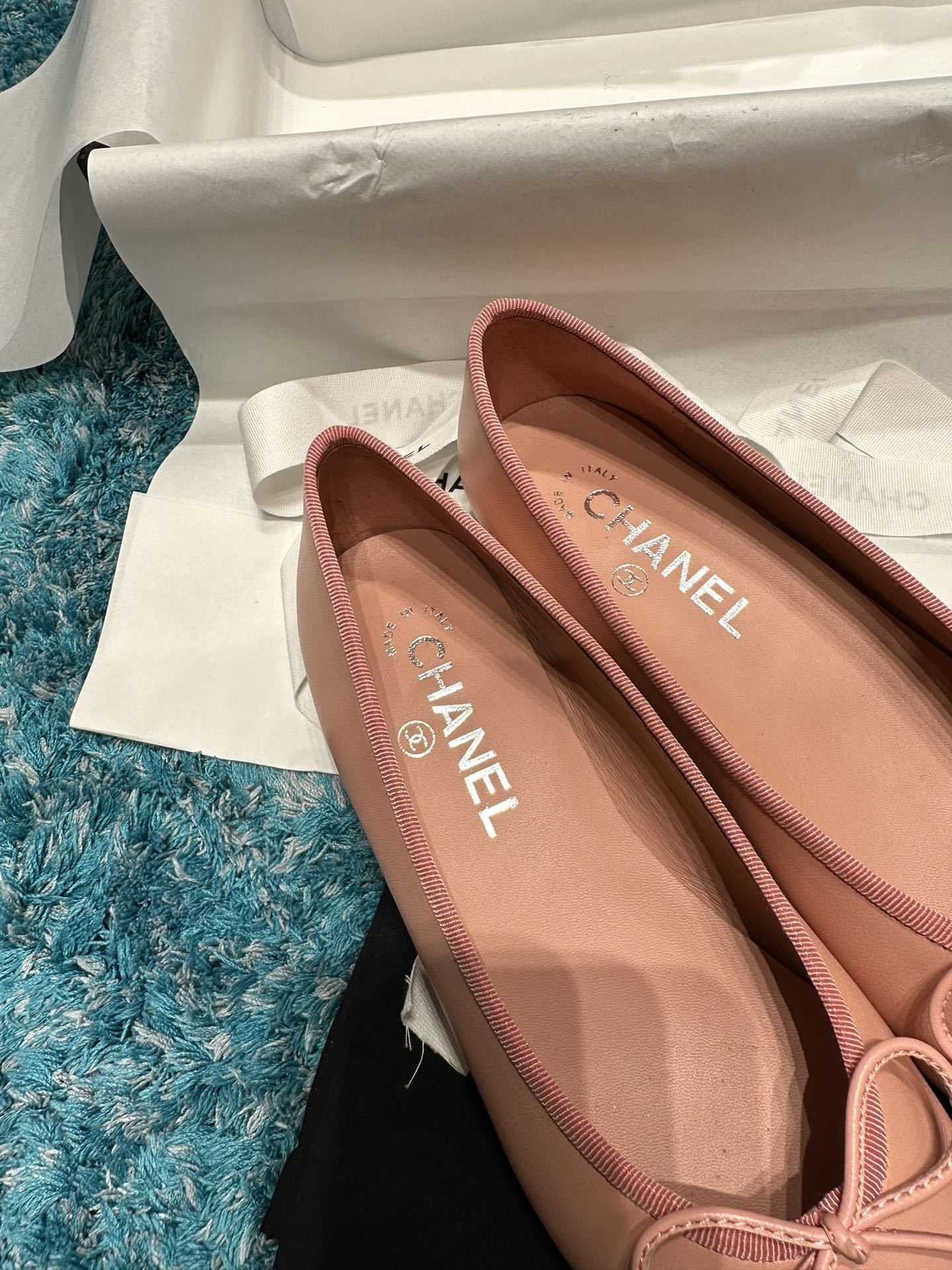 A pair of pink Chanel ballerina flats with black toe caps and bow details sitting in original packaging. - Hình 7