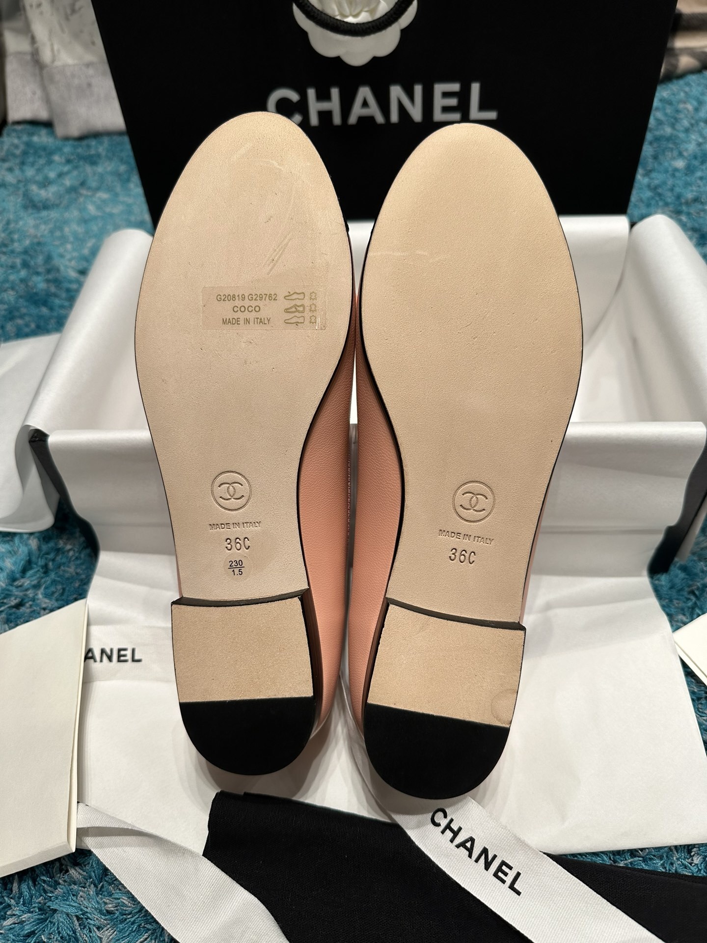A pair of pink Chanel ballerina flats with black toe caps and bow details sitting in original packaging. - Hình 5