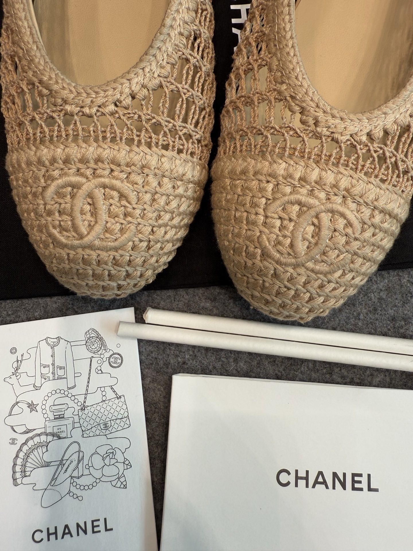 Top view of Chanel beige raffia mesh ballet flats with CC logo on the toe in a luxury box - Hình 7