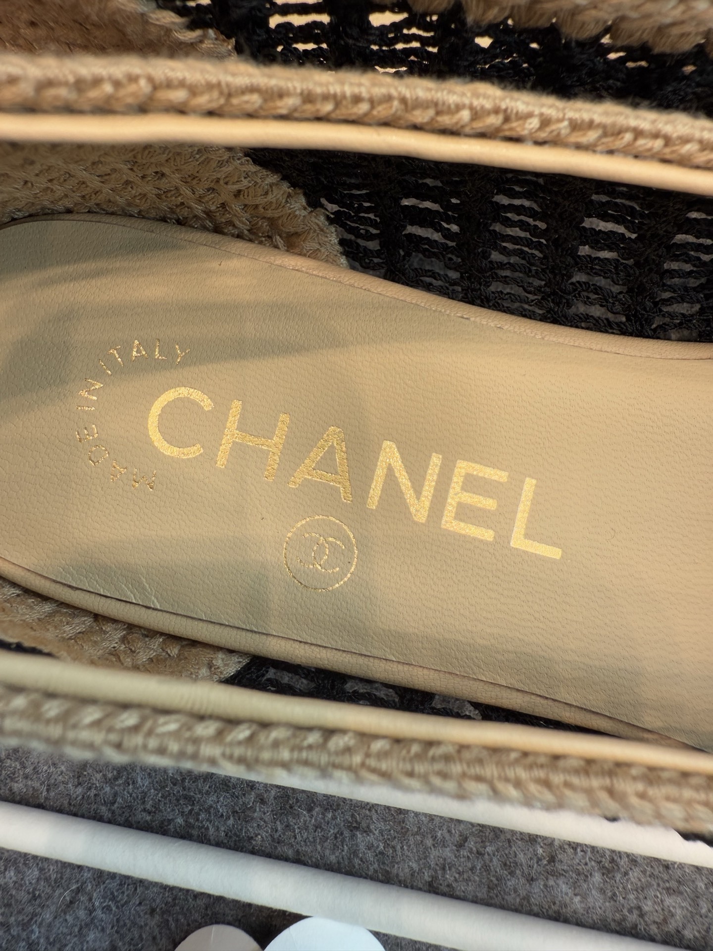 A pair of authentic Chanel beige and black crochet ballet flats with CC logo on the toe, shown with original packaging and camellia flower. - Hình 8
