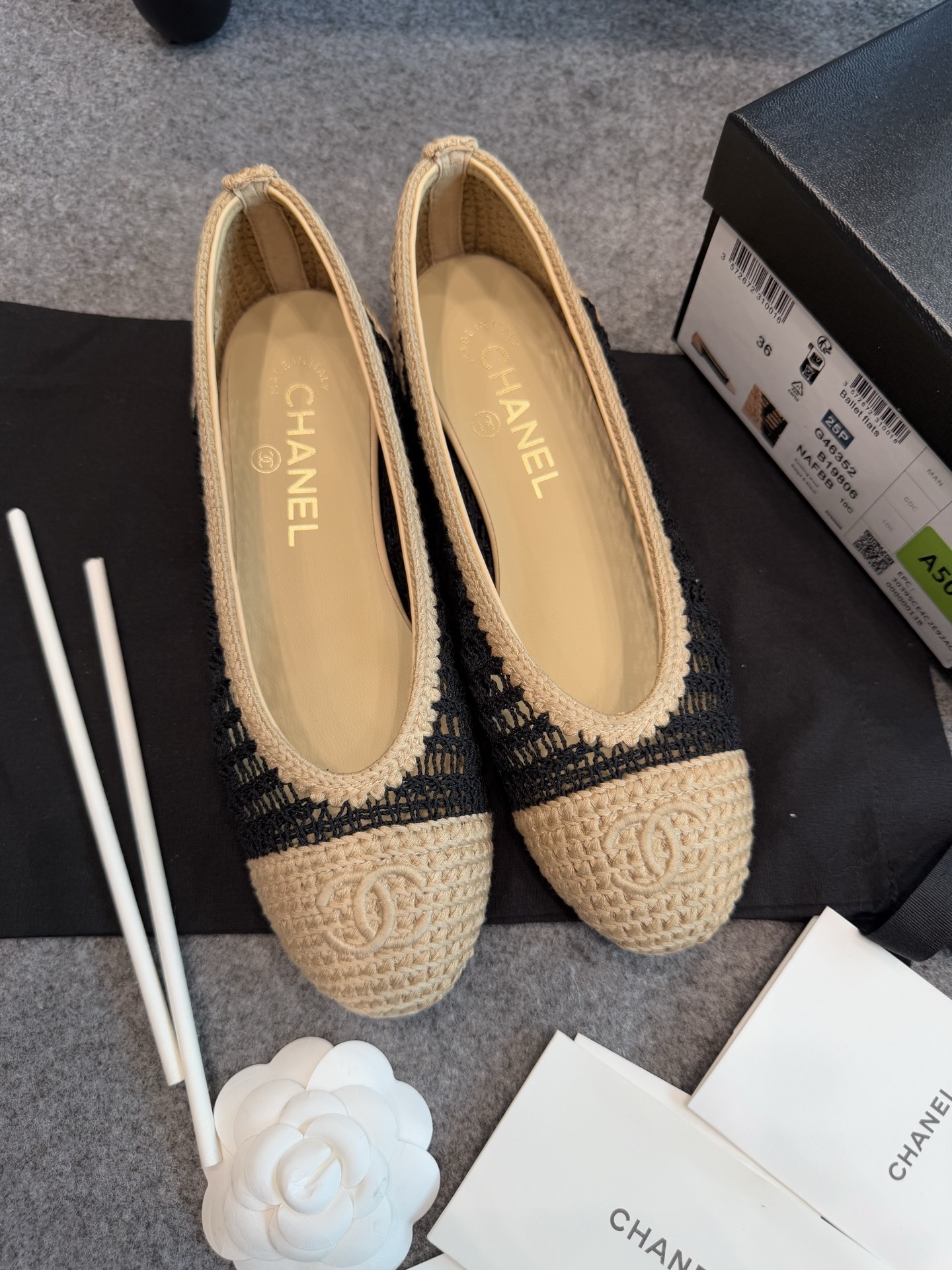 A pair of authentic Chanel beige and black crochet ballet flats with CC logo on the toe, shown with original packaging and camellia flower. - Hình 7