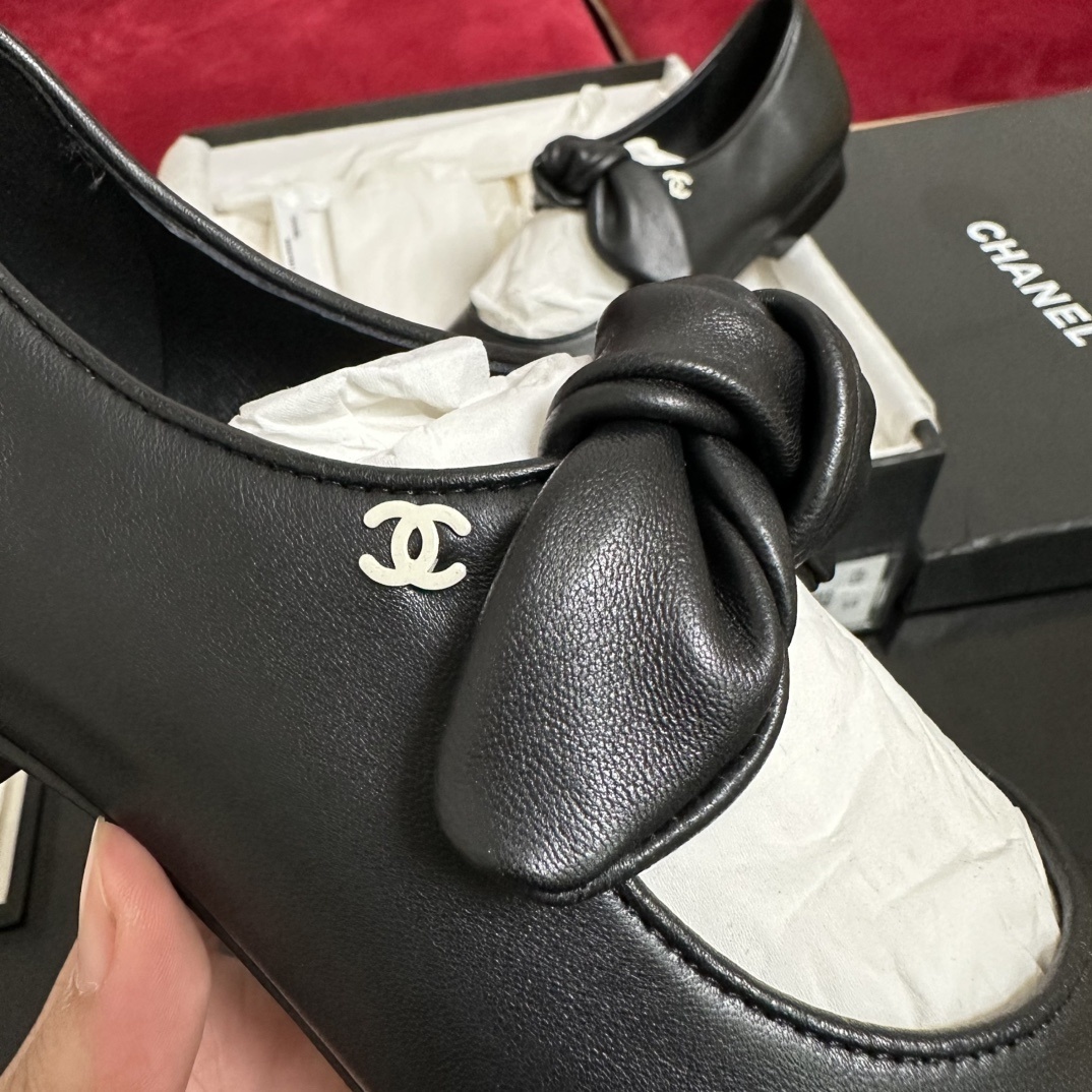 Pair of black Chanel Mary Jane leather flats with a knotted strap and cap toe in original packaging. - Hình 7