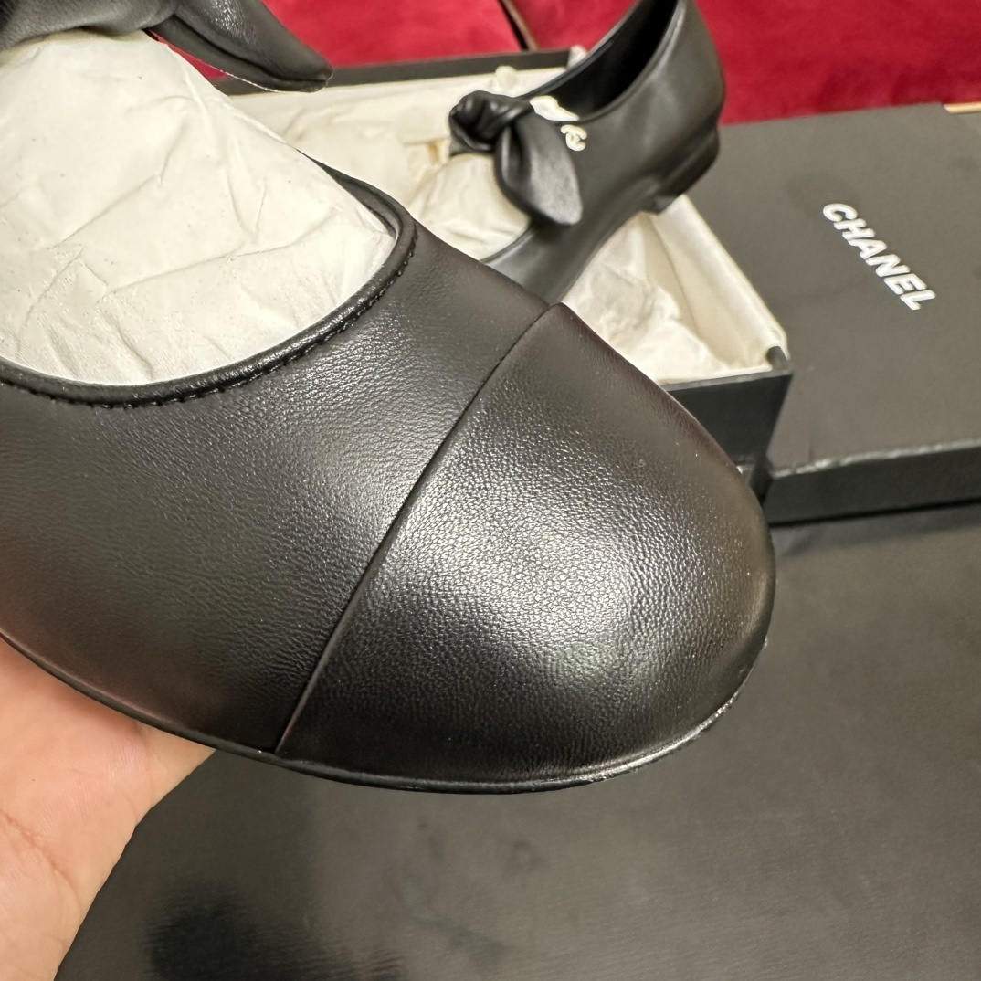 Pair of black Chanel Mary Jane leather flats with a knotted strap and cap toe in original packaging. - Hình 6