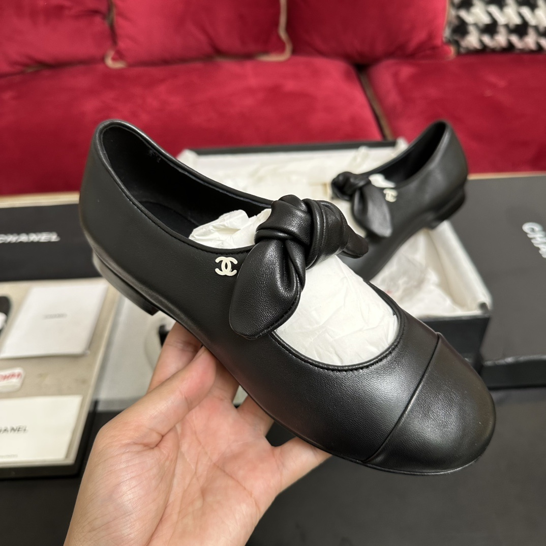 Pair of black Chanel Mary Jane leather flats with a knotted strap and cap toe in original packaging. - Hình 4