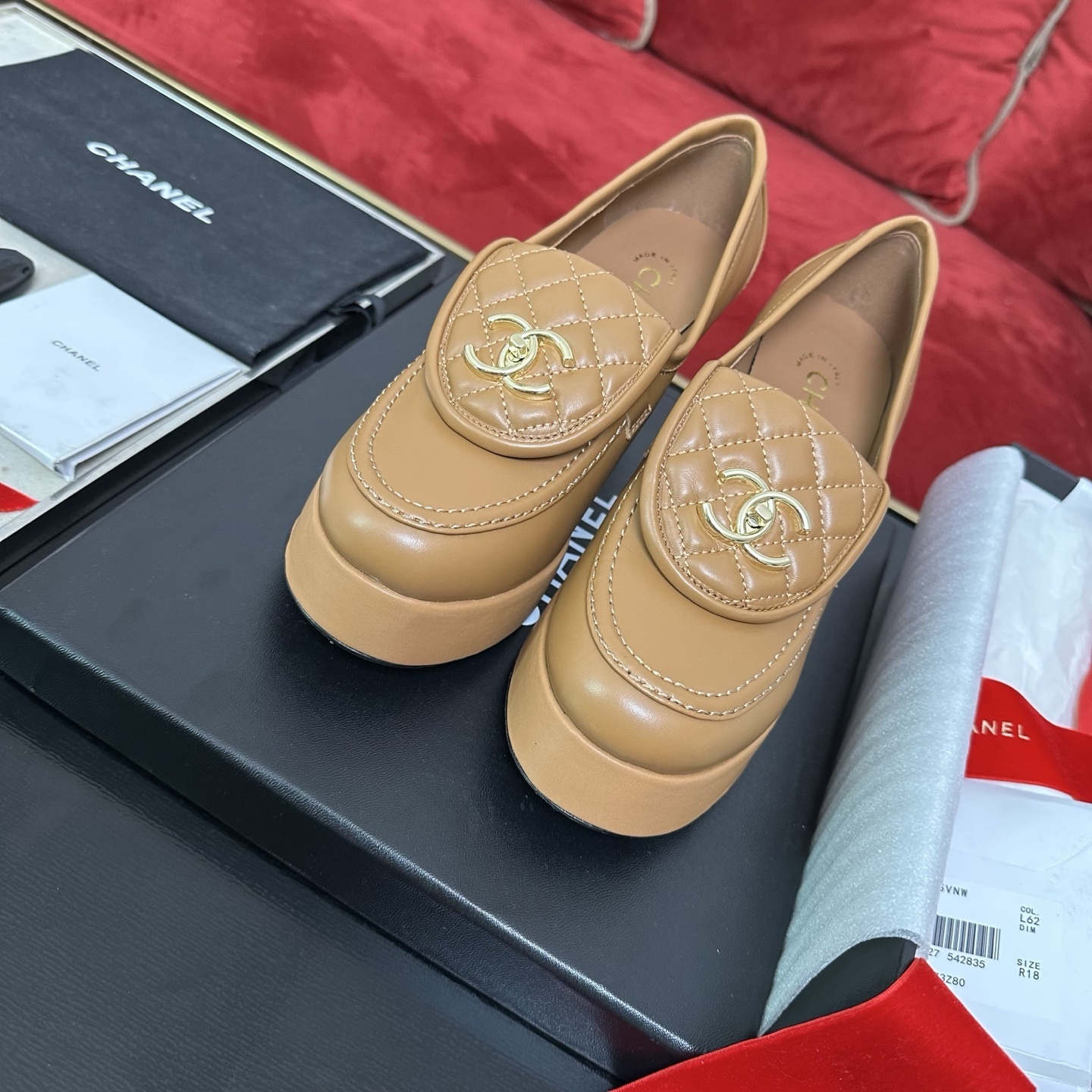 Luxury Chanel tan leather platform loafers with quilted tongue and gold CC logo displayed on a black box. - Hình 2