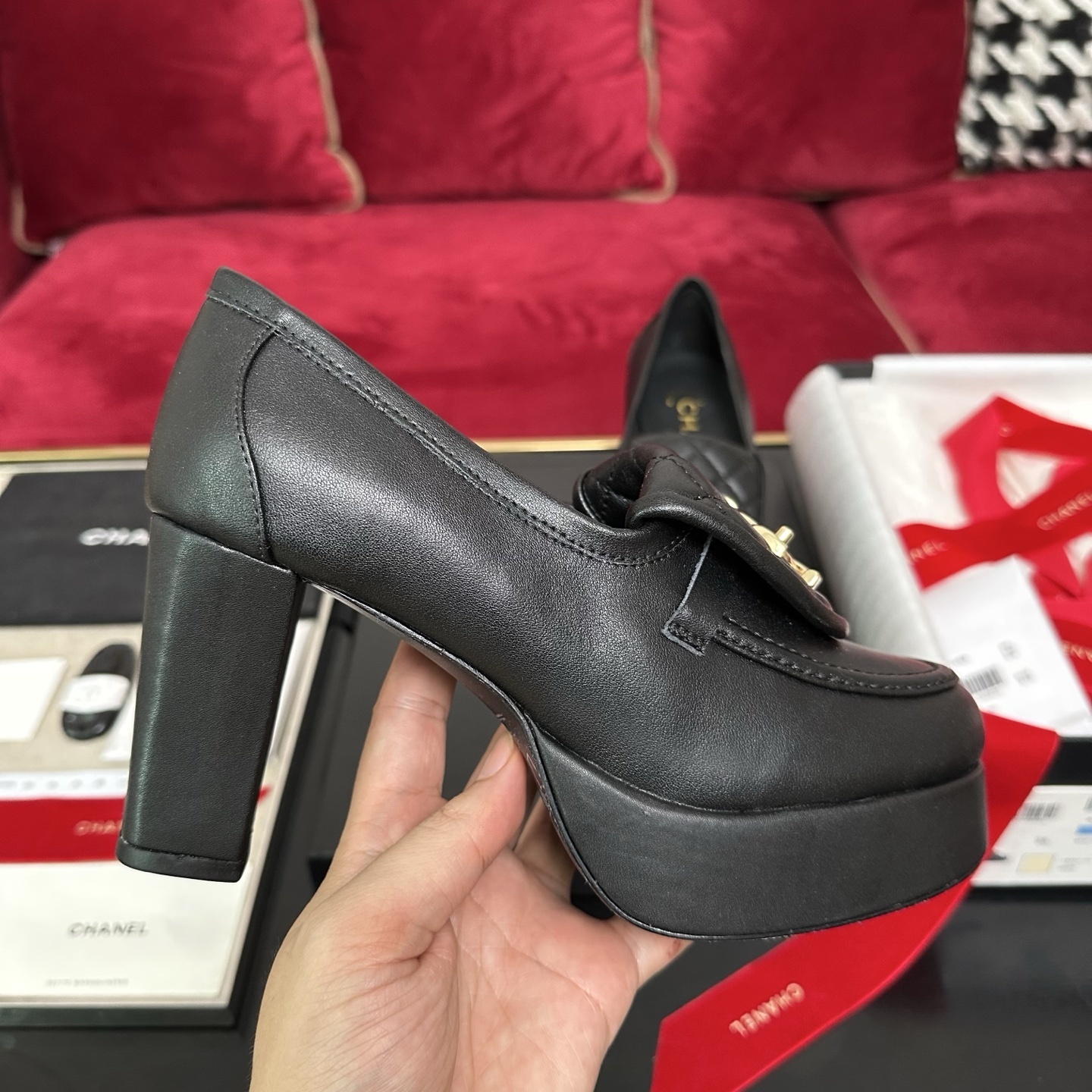 Chanel black quilted leather platform loafers with gold CC logo hardware on a display table with original packaging. - Hình 5