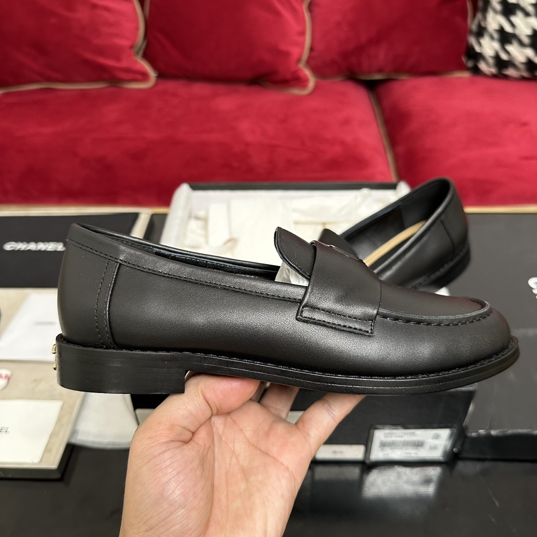 A pair of luxury Chanel black leather loafers with gold CC logo detail in original packaging. - Hình 5