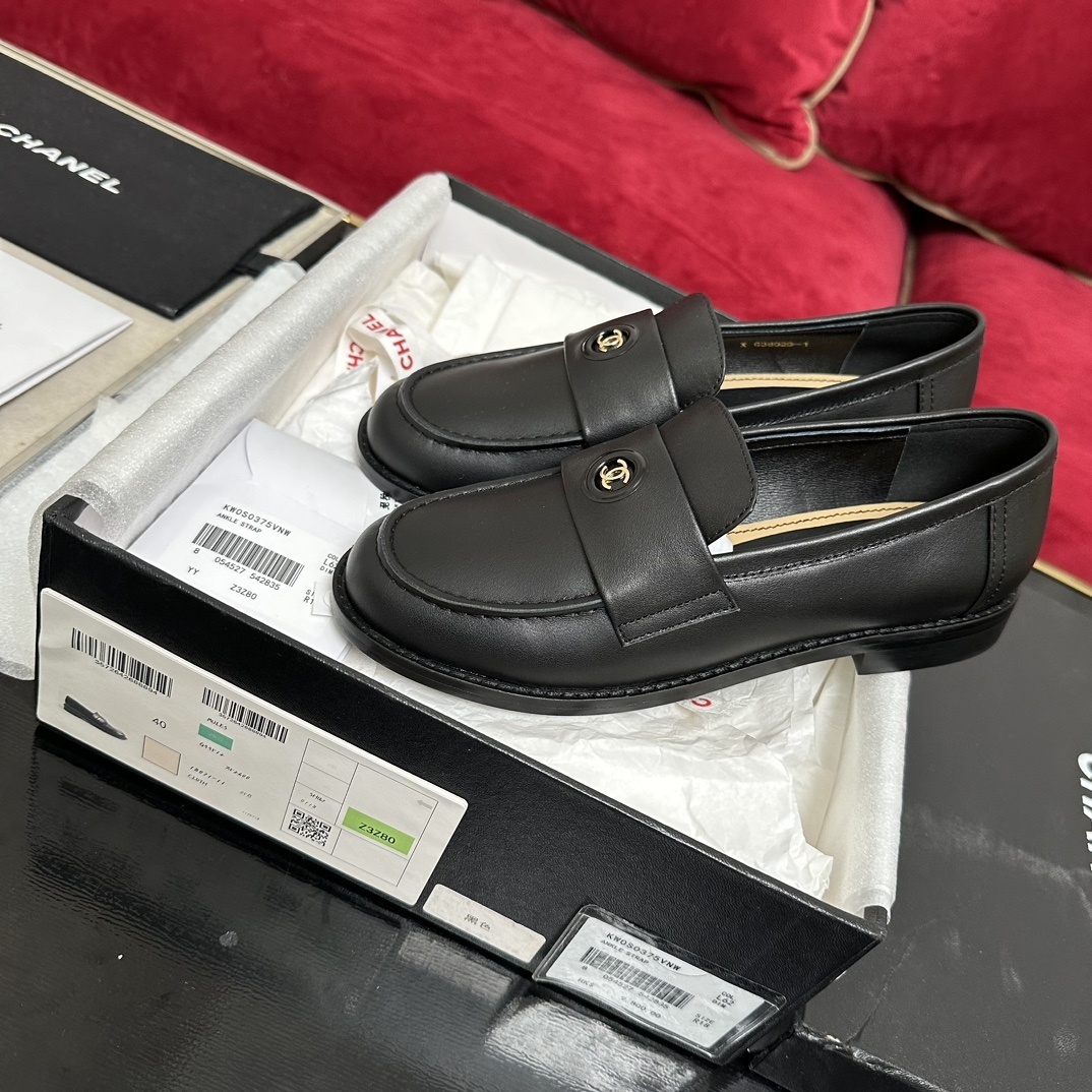 A pair of luxury Chanel black leather loafers with gold CC logo detail in original packaging. - Hình 2