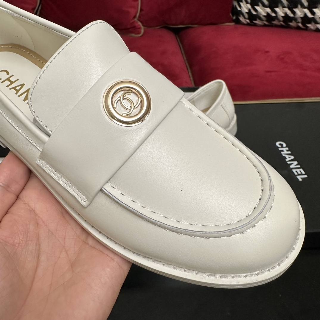 A pair of luxury Chanel white leather loafers with gold CC logo hardware displayed in their original black and white box with authenticity cards. - Hình 6
