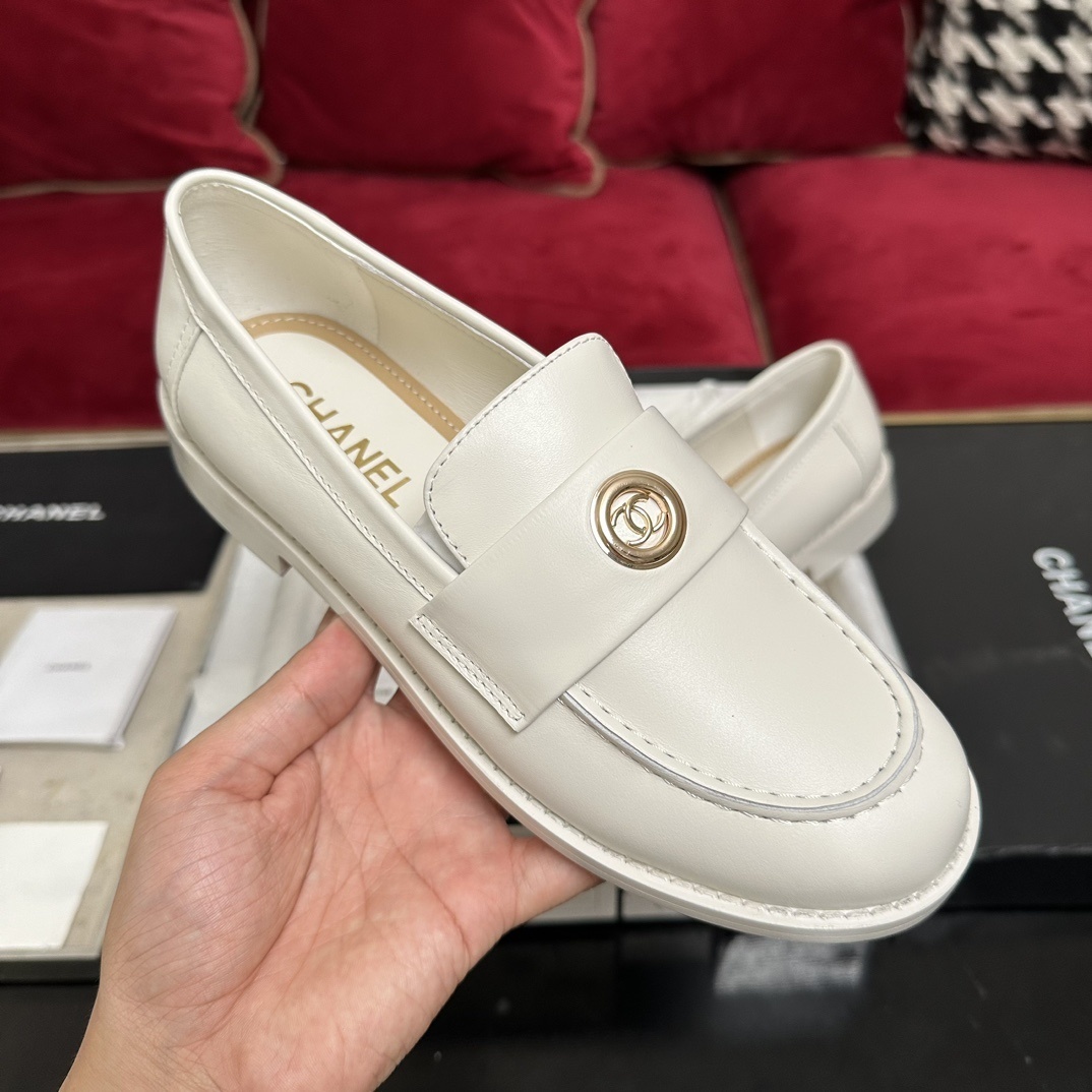 A pair of luxury Chanel white leather loafers with gold CC logo hardware displayed in their original black and white box with authenticity cards. - Hình 4
