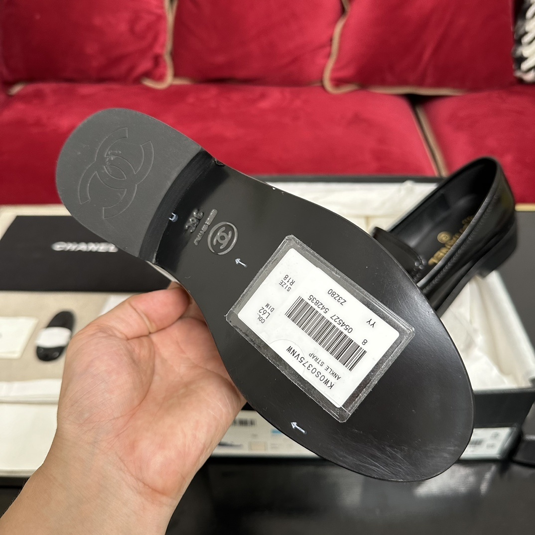 Luxury black Chanel leather loafers with a signature gold CC logo sitting inside their original black designer box. - Hình 9