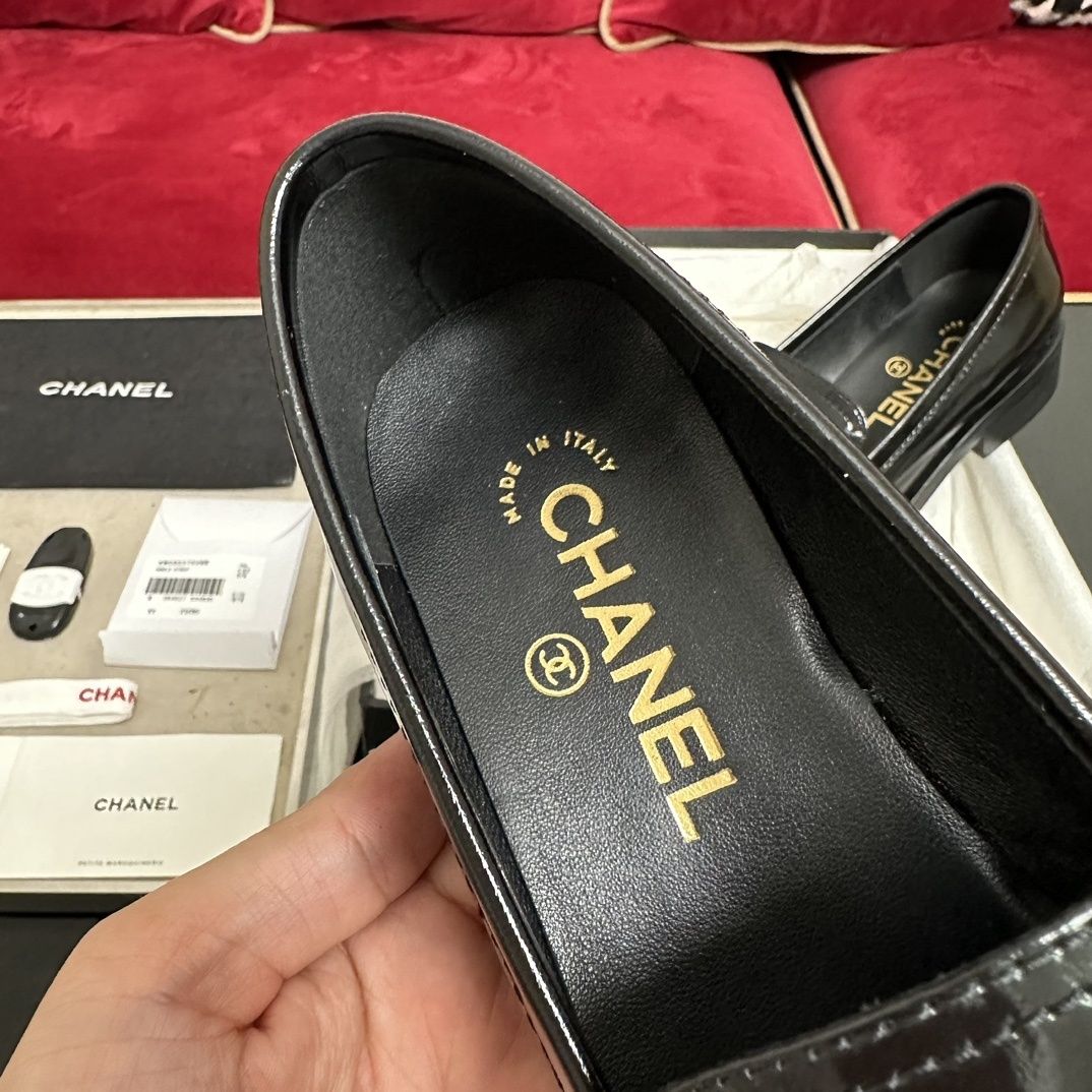 Luxury black Chanel leather loafers with a signature gold CC logo sitting inside their original black designer box. - Hình 7