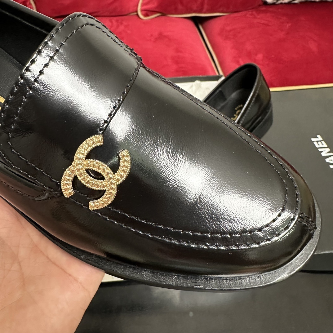Luxury black Chanel leather loafers with a signature gold CC logo sitting inside their original black designer box. - Hình 6
