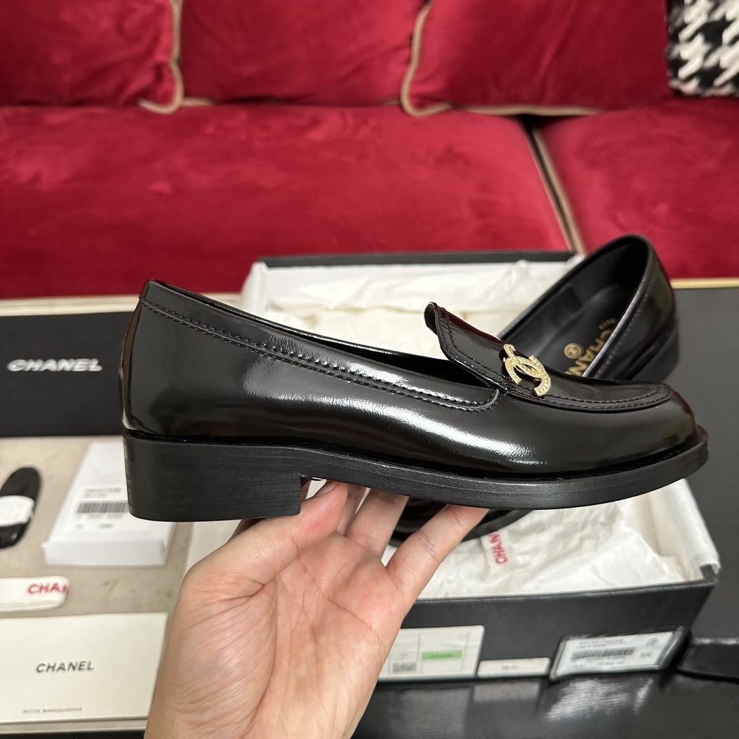 Luxury black Chanel leather loafers with a signature gold CC logo sitting inside their original black designer box. - Hình 5