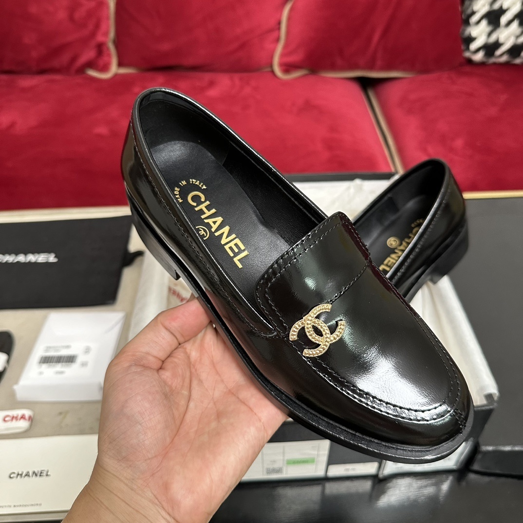 Luxury black Chanel leather loafers with a signature gold CC logo sitting inside their original black designer box. - Hình 4