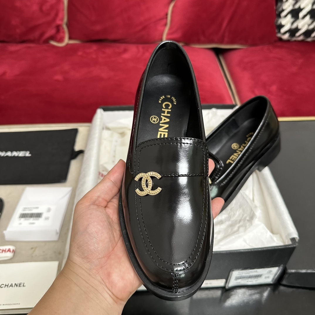 Luxury black Chanel leather loafers with a signature gold CC logo sitting inside their original black designer box. - Hình 3