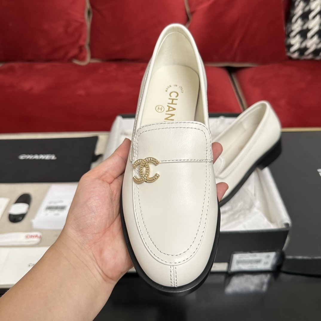 Luxury Chanel white leather loafers with gold CC logo hardware placed in their original black box with accessories - Hình 3