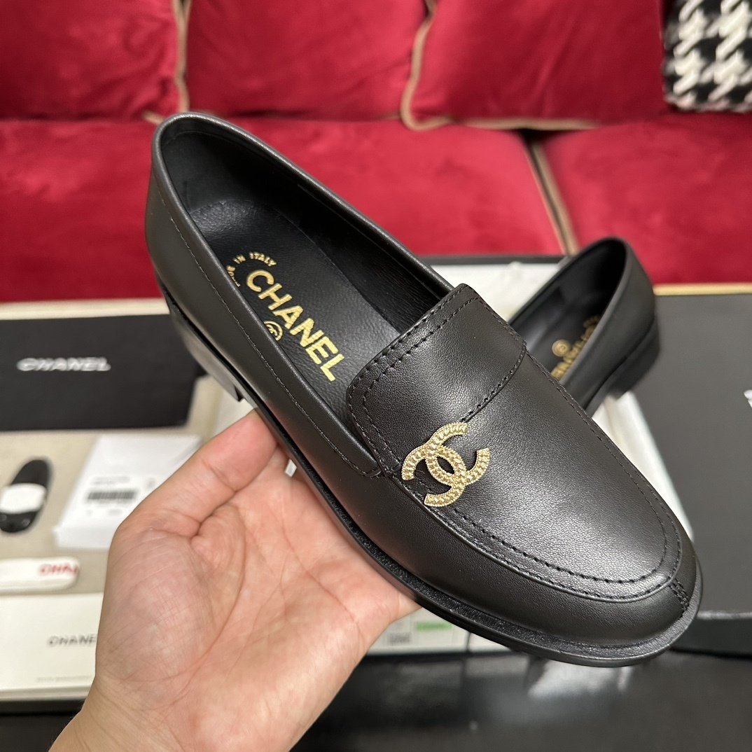 A pair of black leather Chanel loafers with a gold CC logo presented in their original box with a dust bag and cards. - Hình 4