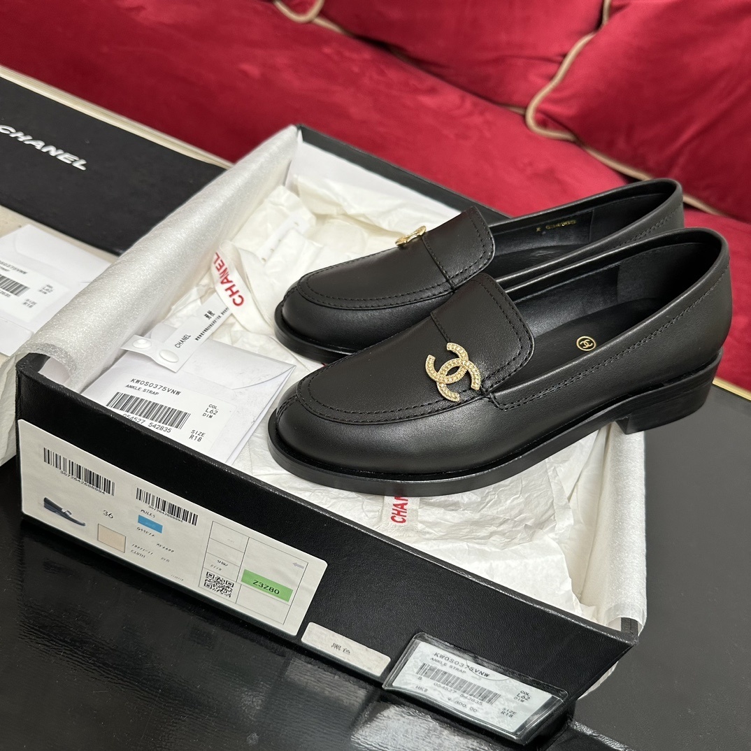 A pair of black leather Chanel loafers with a gold CC logo presented in their original box with a dust bag and cards. - Hình 2