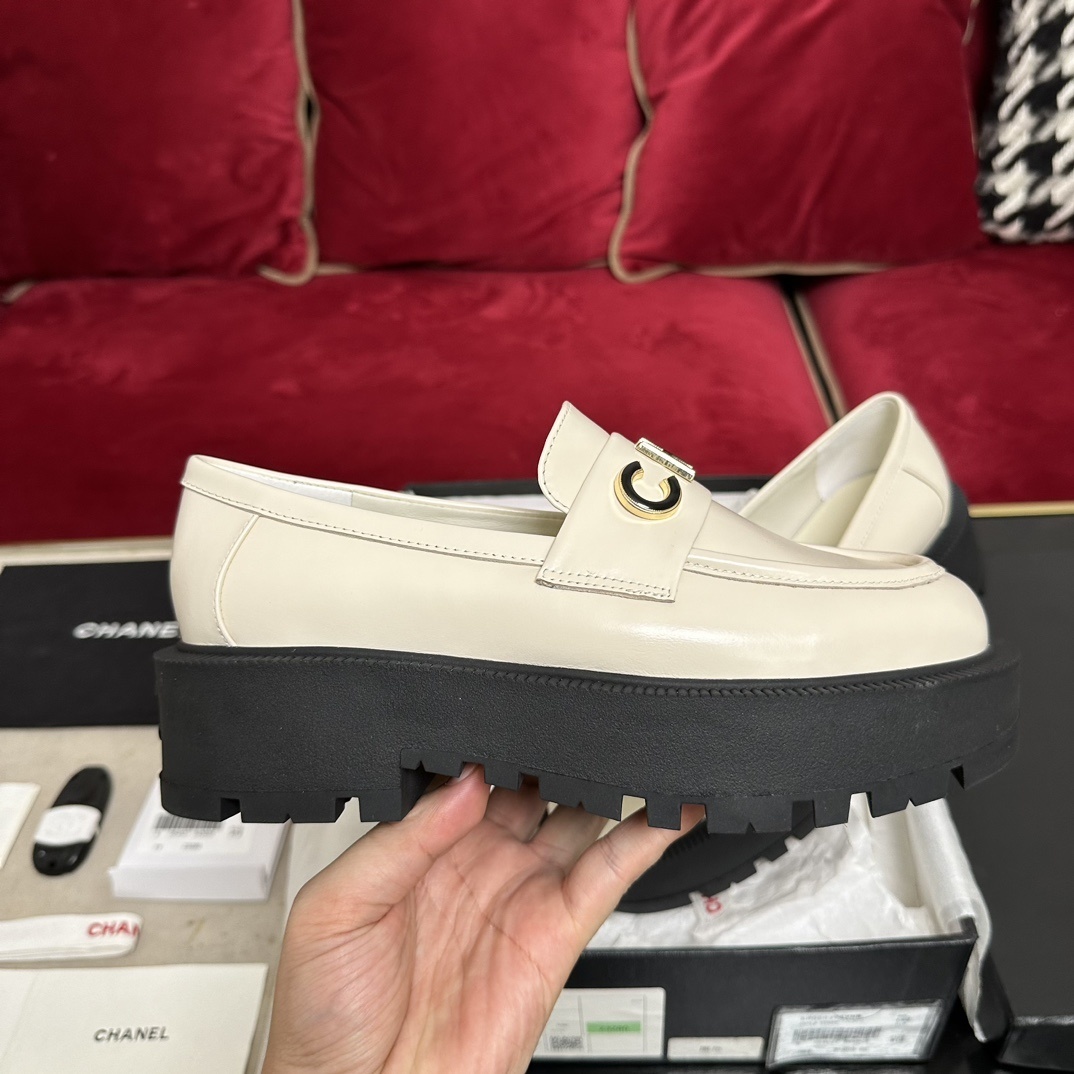 Luxury Chanel cream leather loafers with chunky black platform soles and gold metal logo lettering on the front strap. - Hình 5