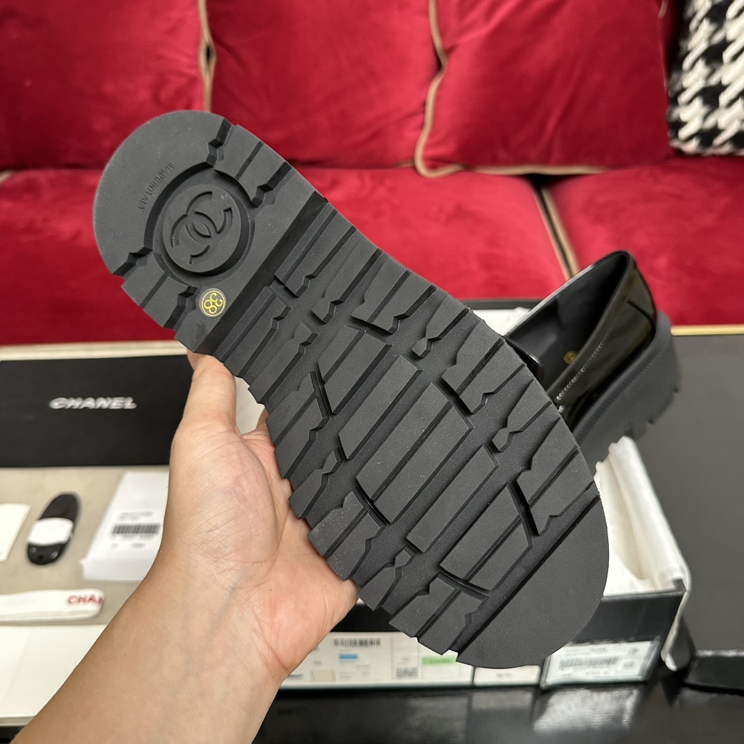 High-end Chanel black patent leather platform loafers with gold-tone CHANEL metal logo on the strap, displayed with original packaging. - Hình 9