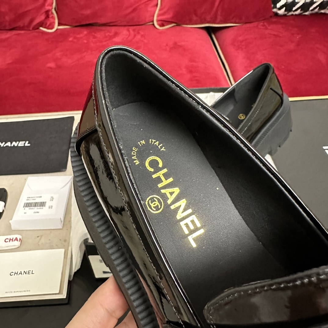 High-end Chanel black patent leather platform loafers with gold-tone CHANEL metal logo on the strap, displayed with original packaging. - Hình 7