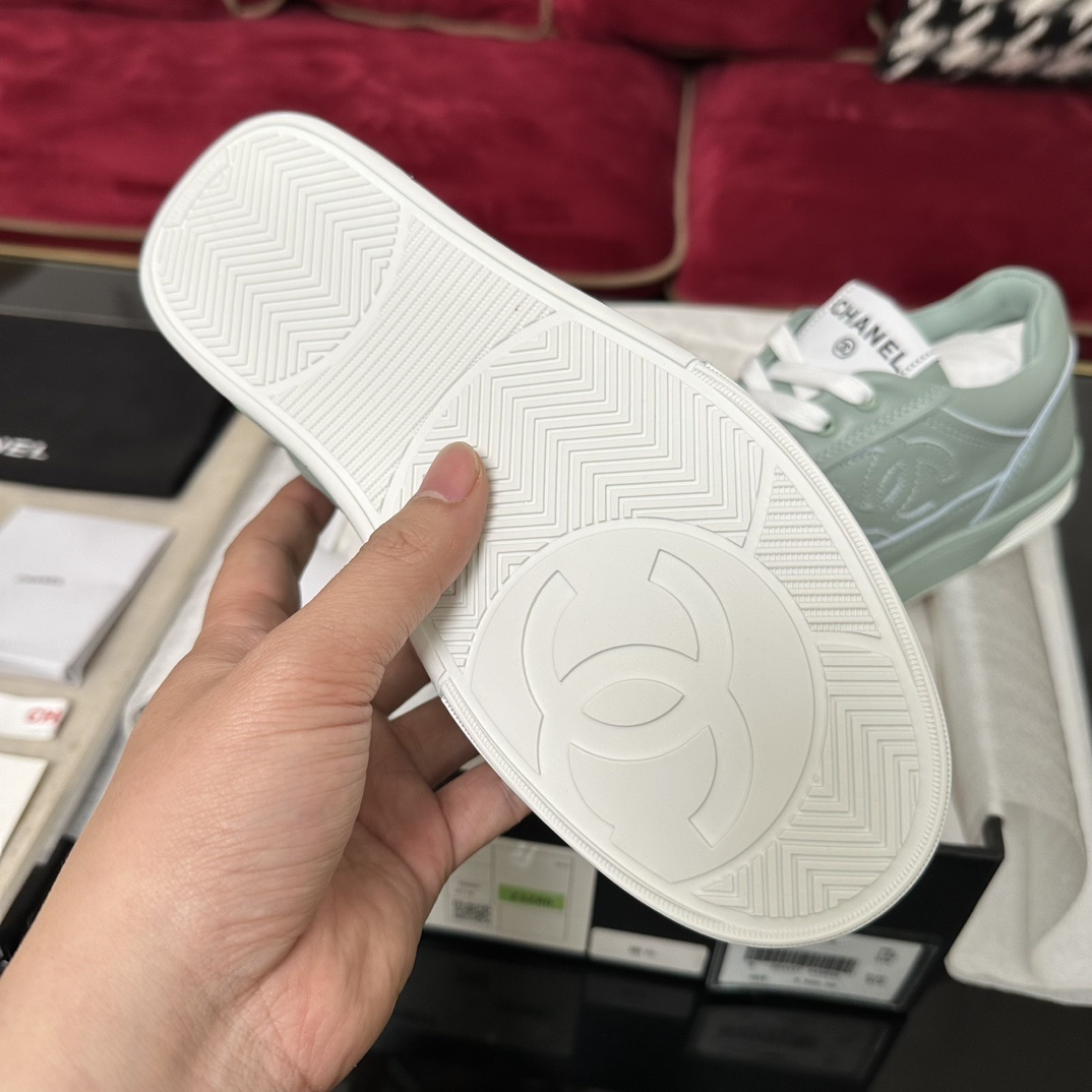 A pair of mint green Chanel leather sneakers with white laces and embossed CC logo in their original black box. - Hình 9