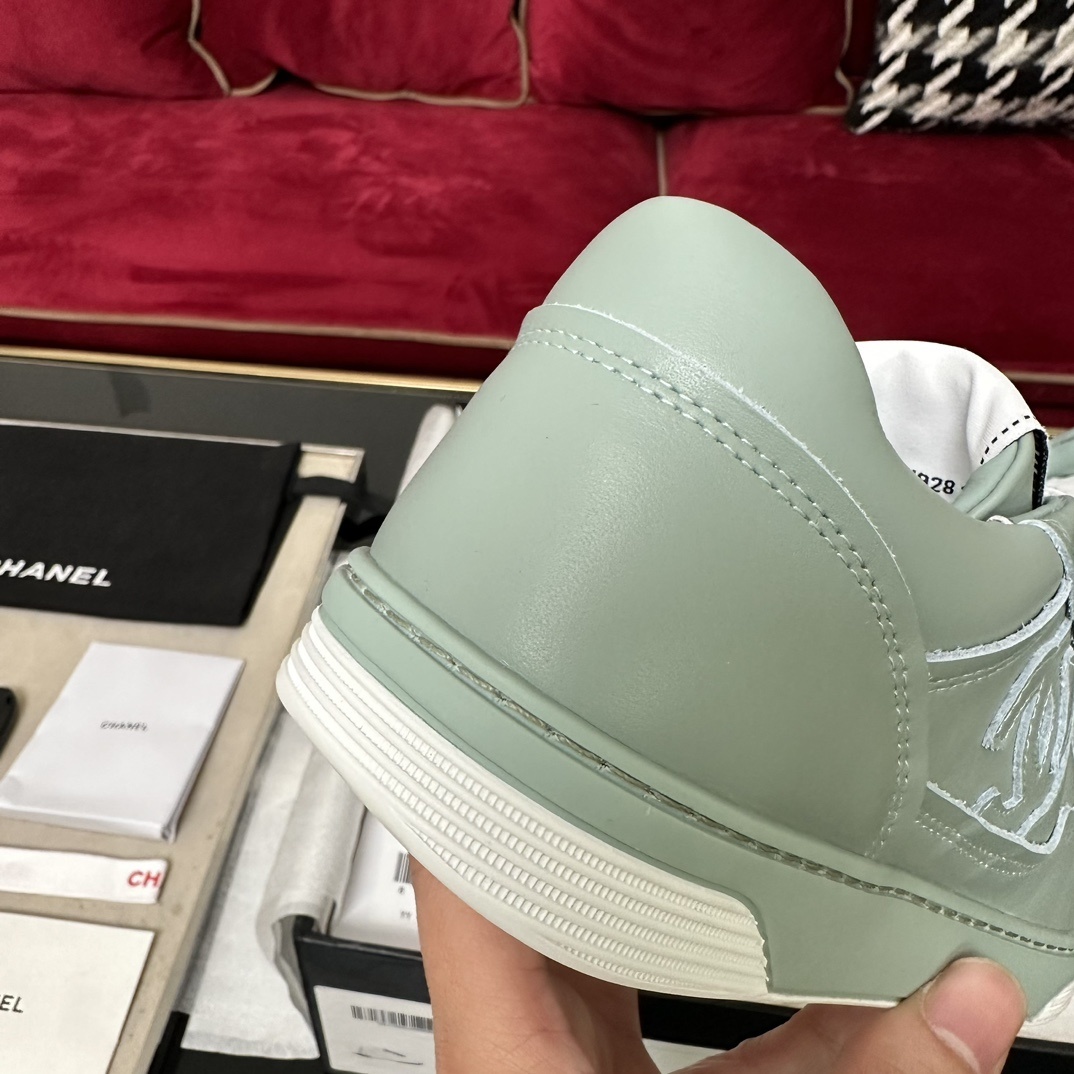 A pair of mint green Chanel leather sneakers with white laces and embossed CC logo in their original black box. - Hình 8