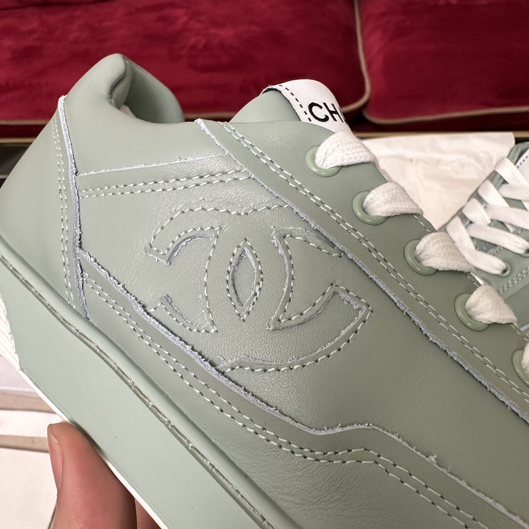 A pair of mint green Chanel leather sneakers with white laces and embossed CC logo in their original black box. - Hình 7