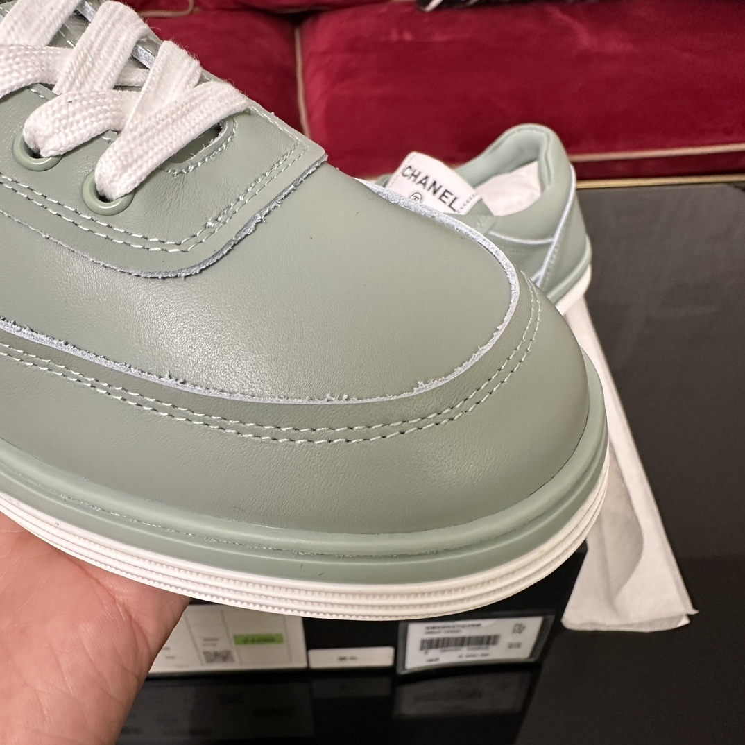 A pair of mint green Chanel leather sneakers with white laces and embossed CC logo in their original black box. - Hình 6