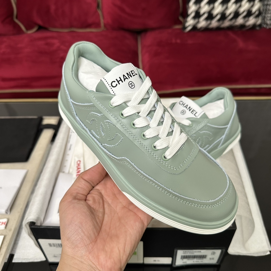 A pair of mint green Chanel leather sneakers with white laces and embossed CC logo in their original black box. - Hình 4