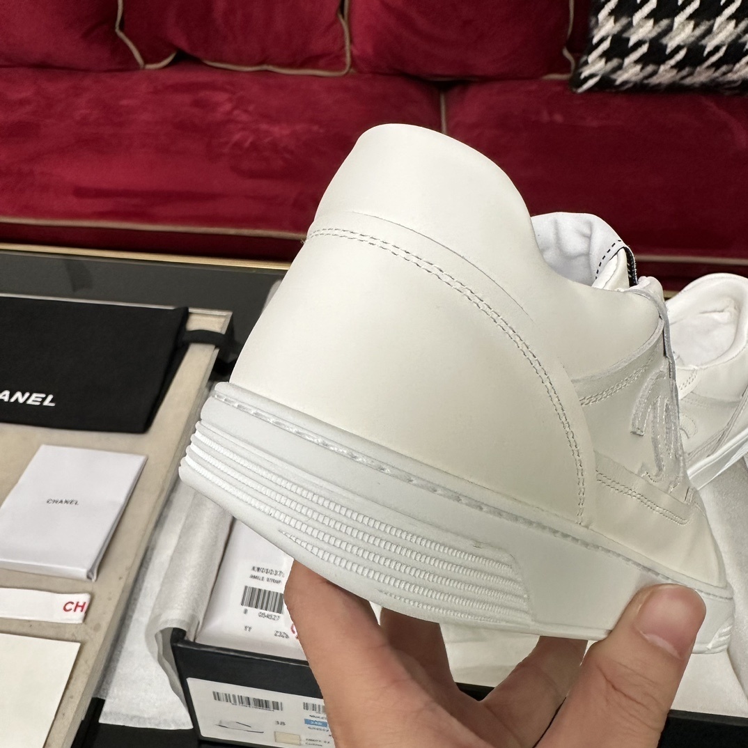 Close-up of the white rubber sole of a Chanel sneaker featuring the interlocking CC logo and herringbone traction pattern. - Hình 10