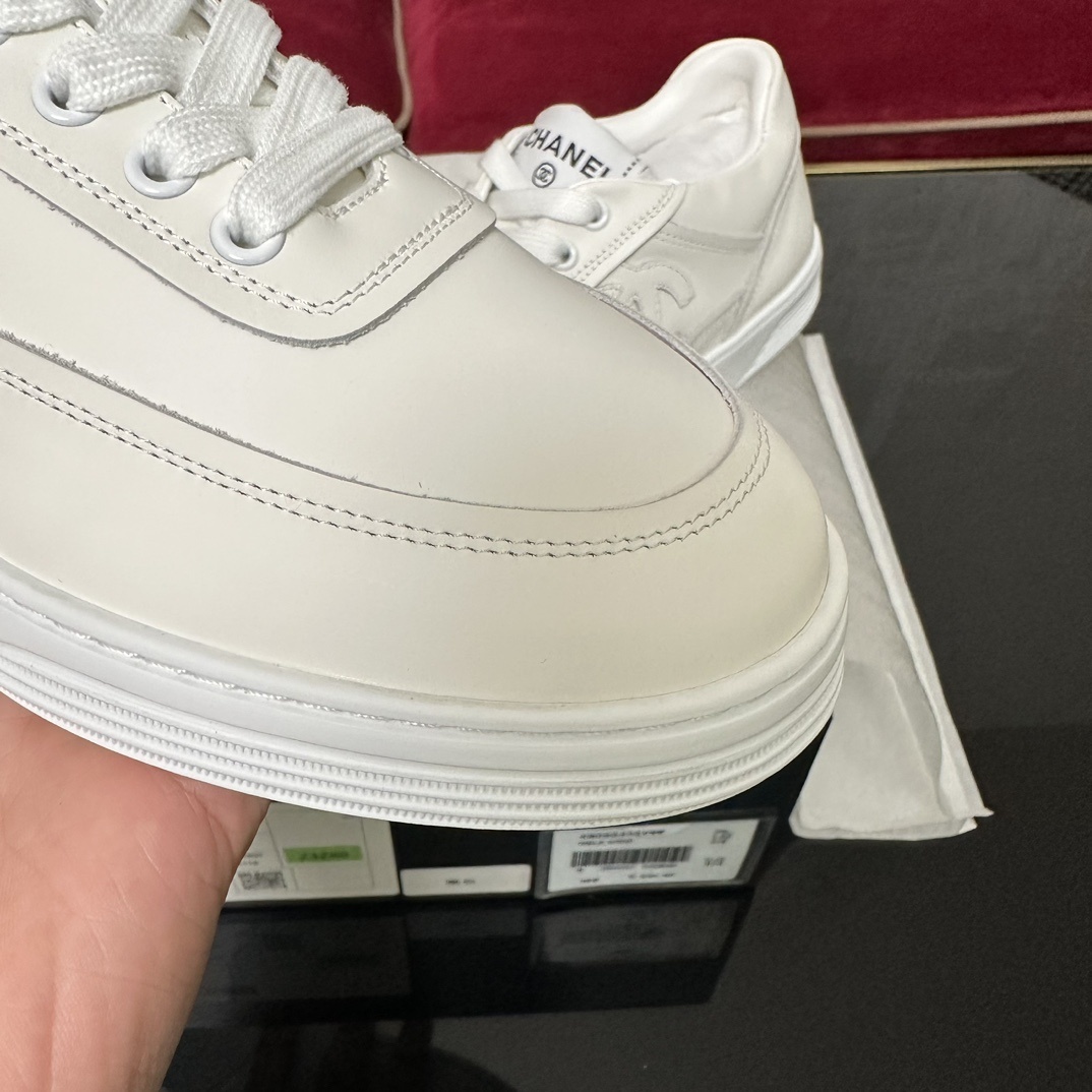 Close-up of the white rubber sole of a Chanel sneaker featuring the interlocking CC logo and herringbone traction pattern. - Hình 8