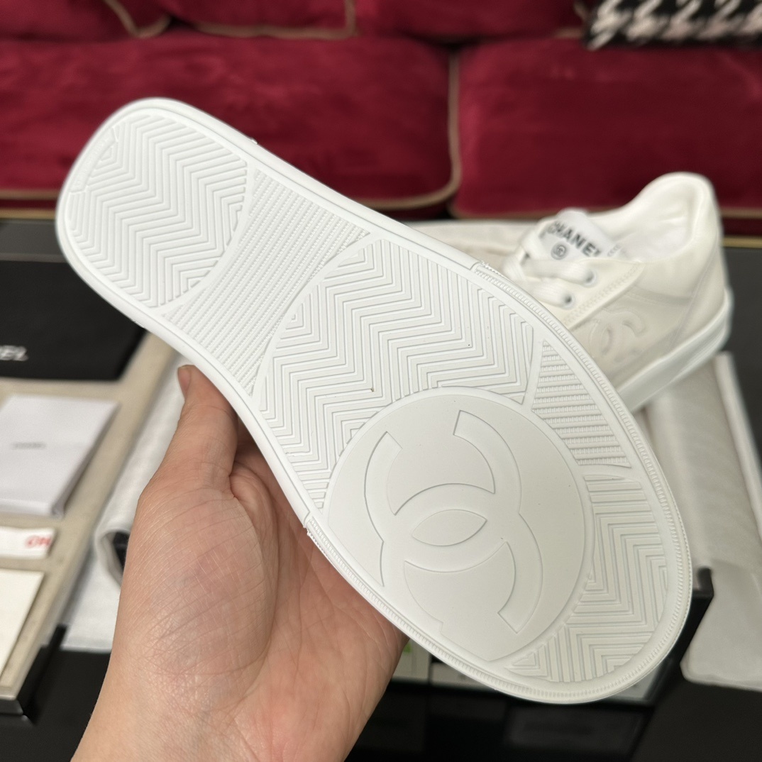 Close-up of the white rubber sole of a Chanel sneaker featuring the interlocking CC logo and herringbone traction pattern. - Hình 2