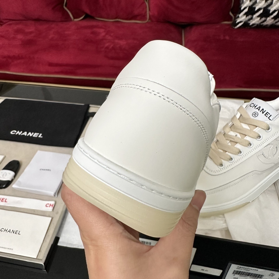 Authentic white Chanel leather sneakers with embossed CC logo and cream laces in original luxury packaging. - Hình 8