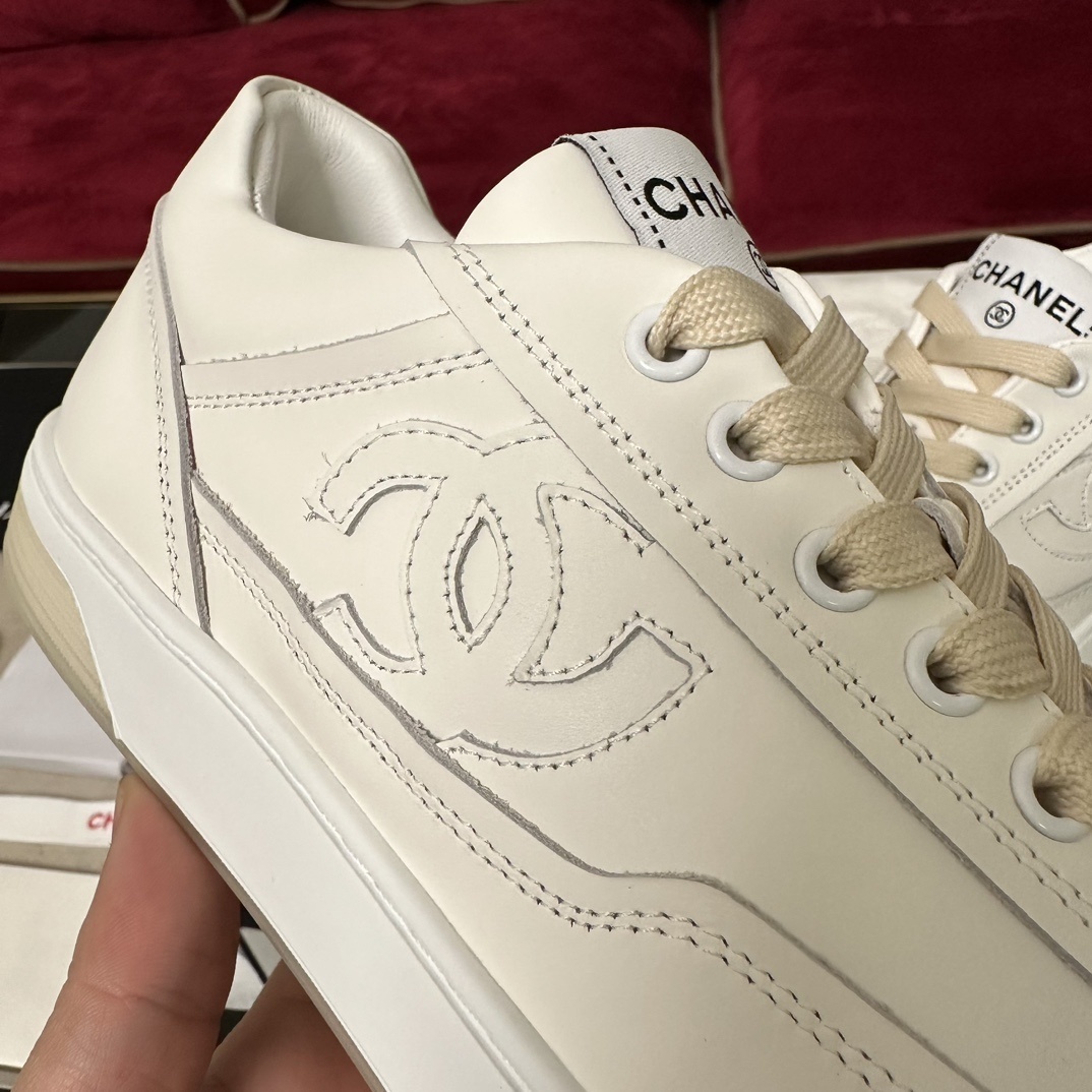 Authentic white Chanel leather sneakers with embossed CC logo and cream laces in original luxury packaging. - Hình 7